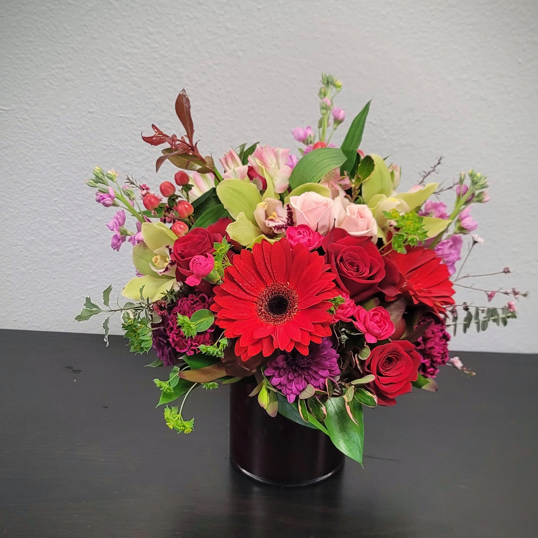 Sweet Amor - The perfect way to show your love and affection to that special someone in your life. This stunning arrangement features a mix of delicate pink and red roses, topped with cymbidium Orchids.   Expertly arranged with fresh seasonal blooms to create a romantic and elegant bouquet. Perfect for Valentine's Day, anniversary, or just because.  Approximate Size 16"H x16" W. Order and experience the charm today! 