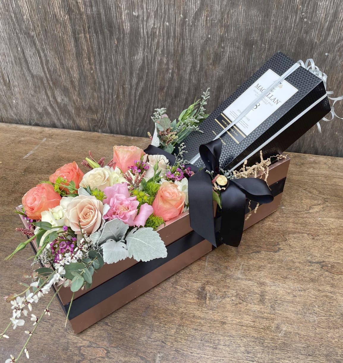 Rectangular gift box with pastel roses and a black ribbon