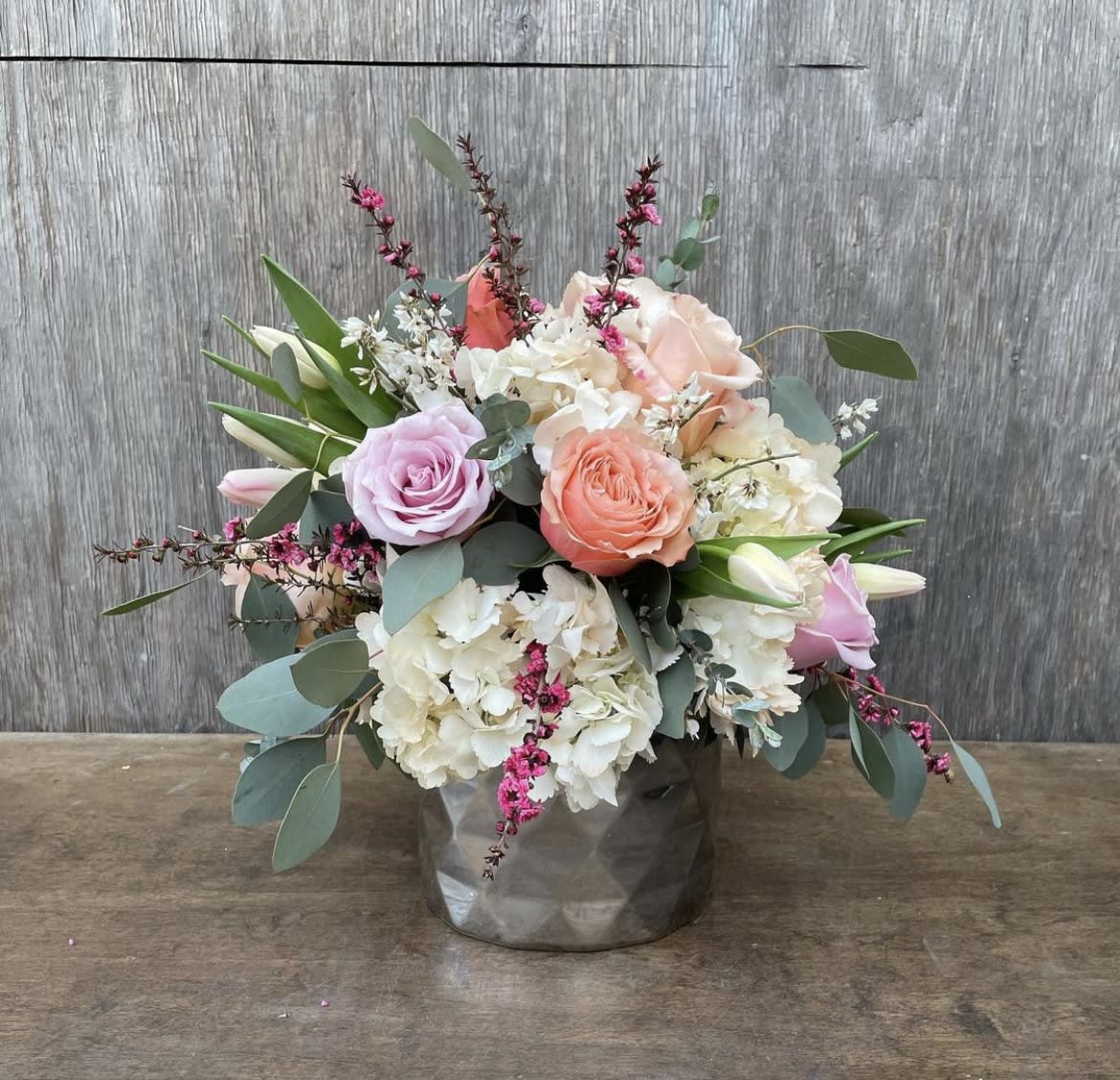 Bouquet of pastel roses and white hydrangeas in a gray vase