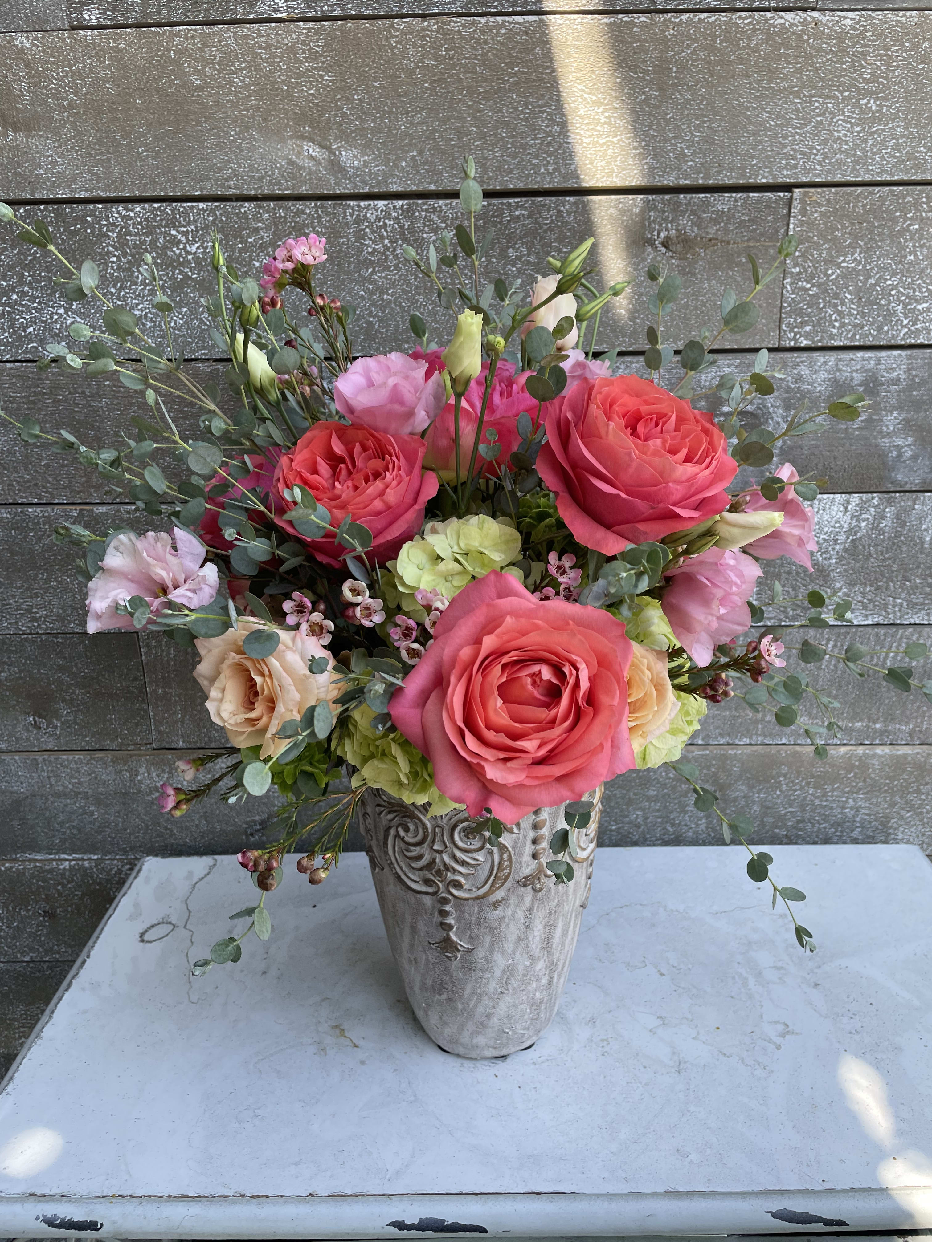 Pink and peach roses arranged in a decorative vase