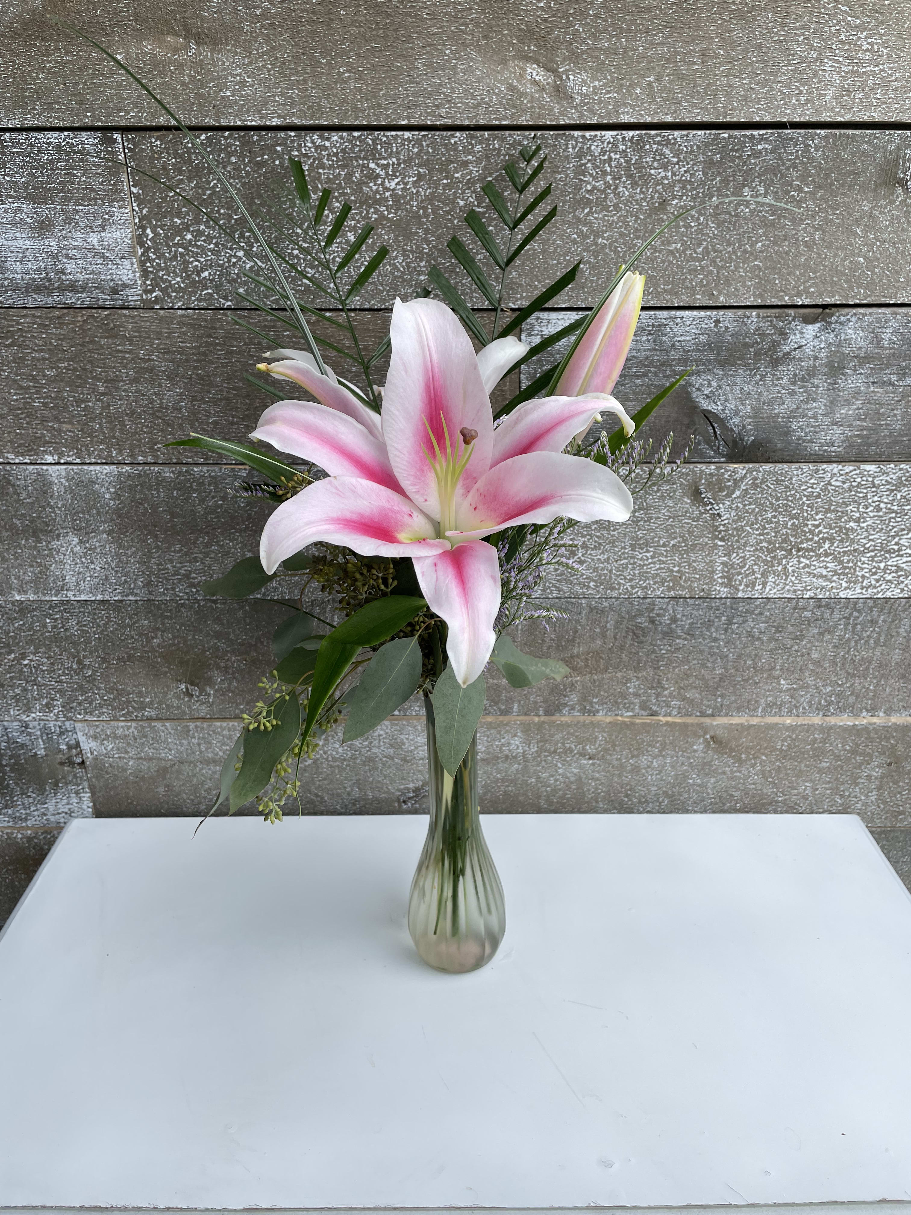 Pink lily arrangement in a clear glass vase