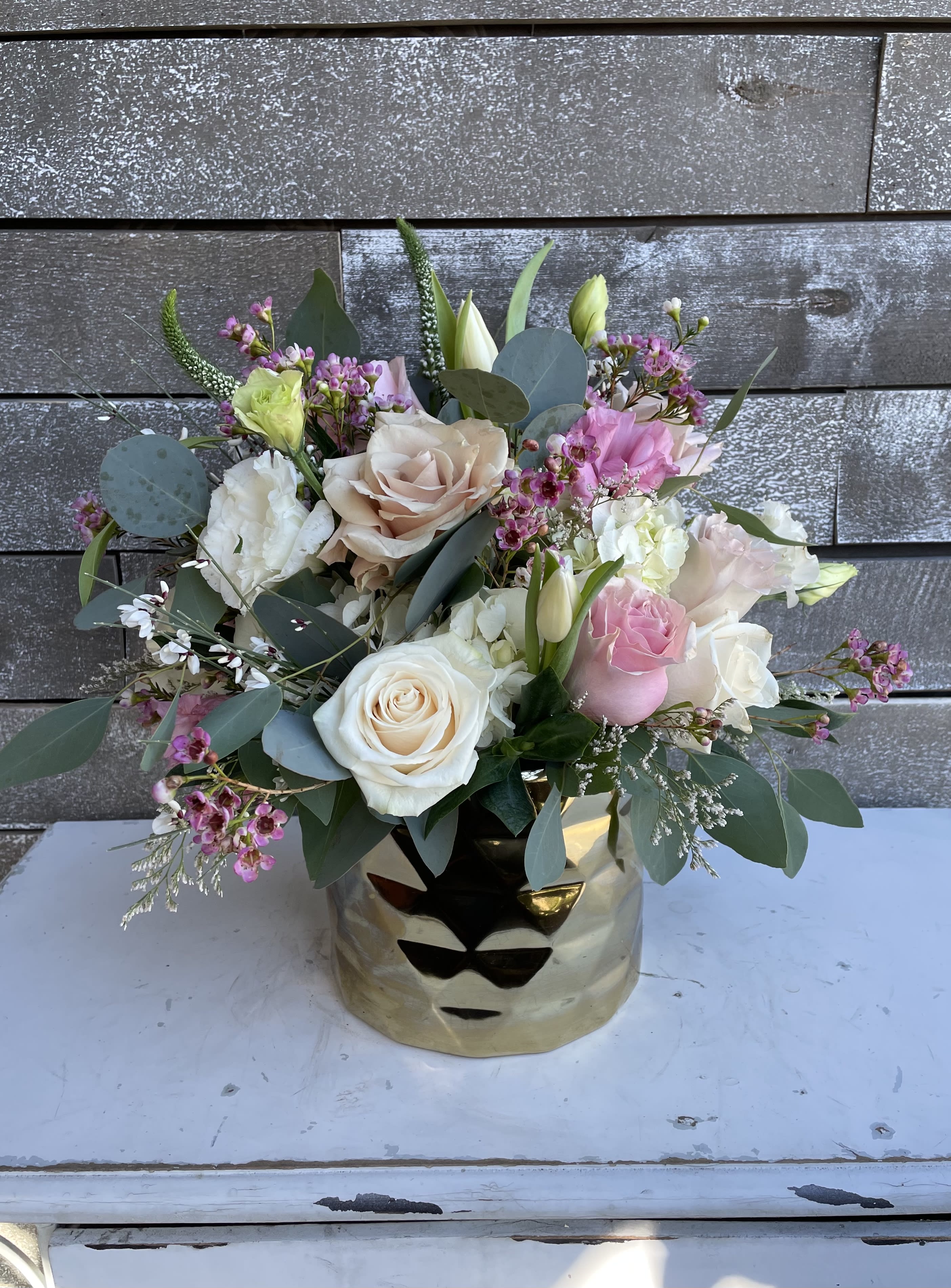Mixed bouquet of pink and white roses in a gold vase