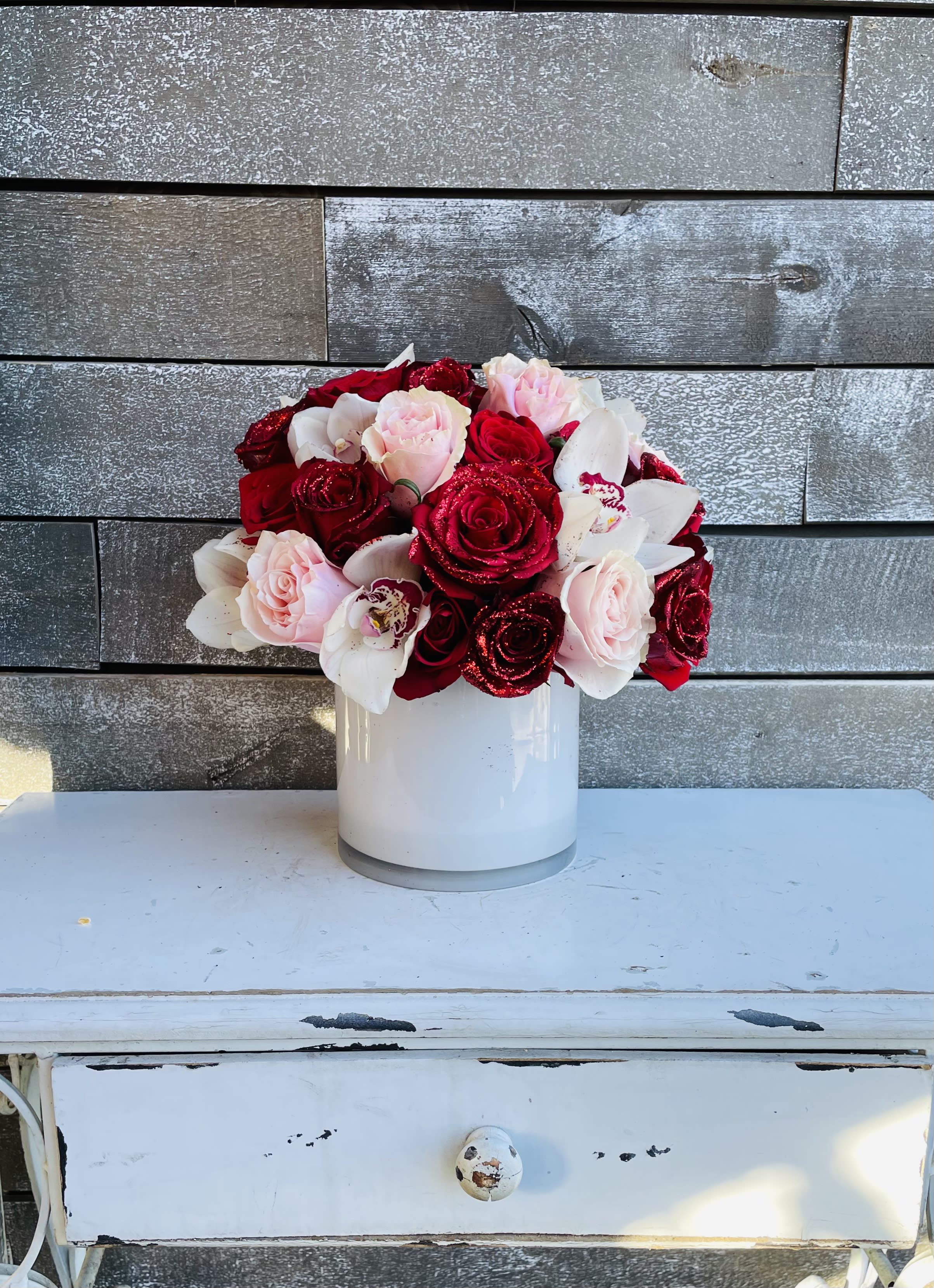 Bouquet of red and pink roses in a white vase
