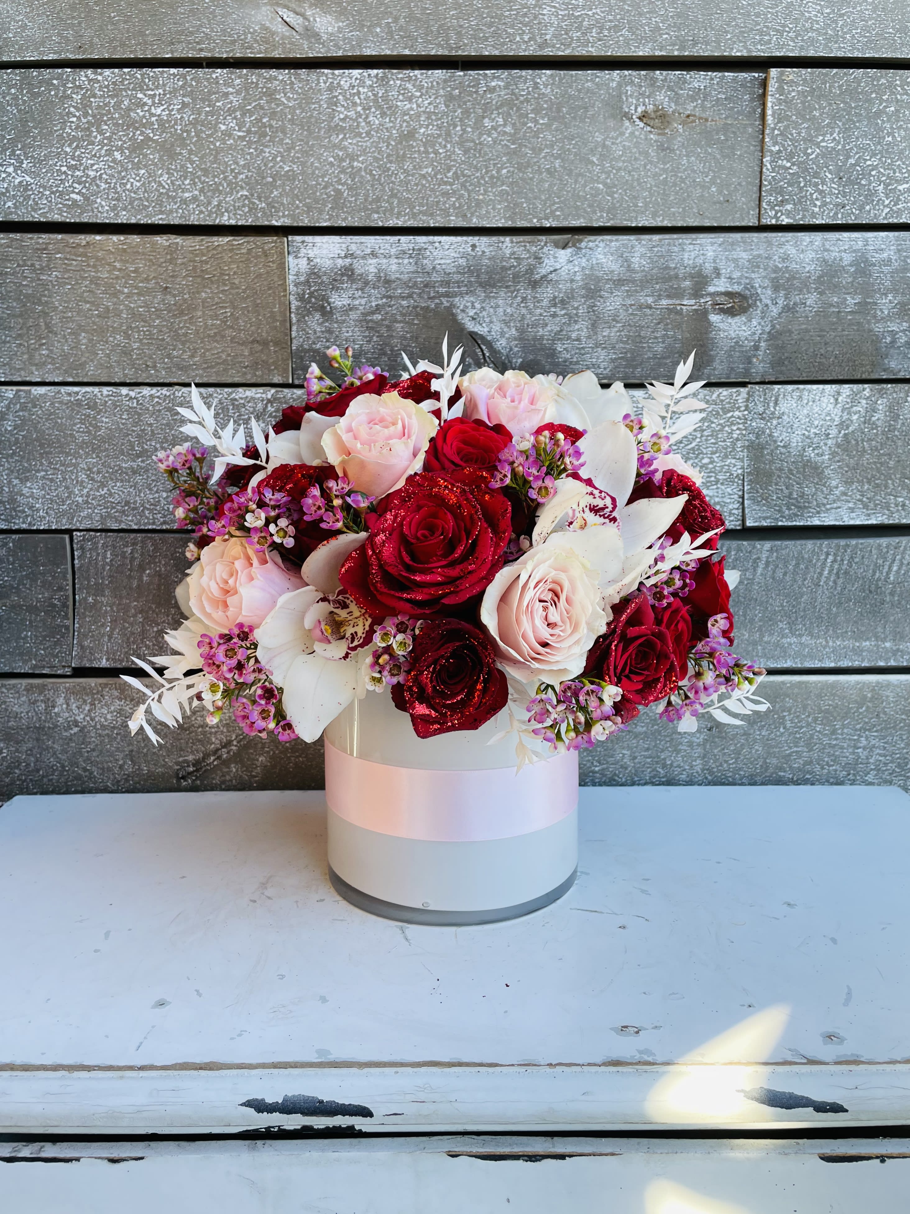 Bouquet of red and blush roses in a white hat box