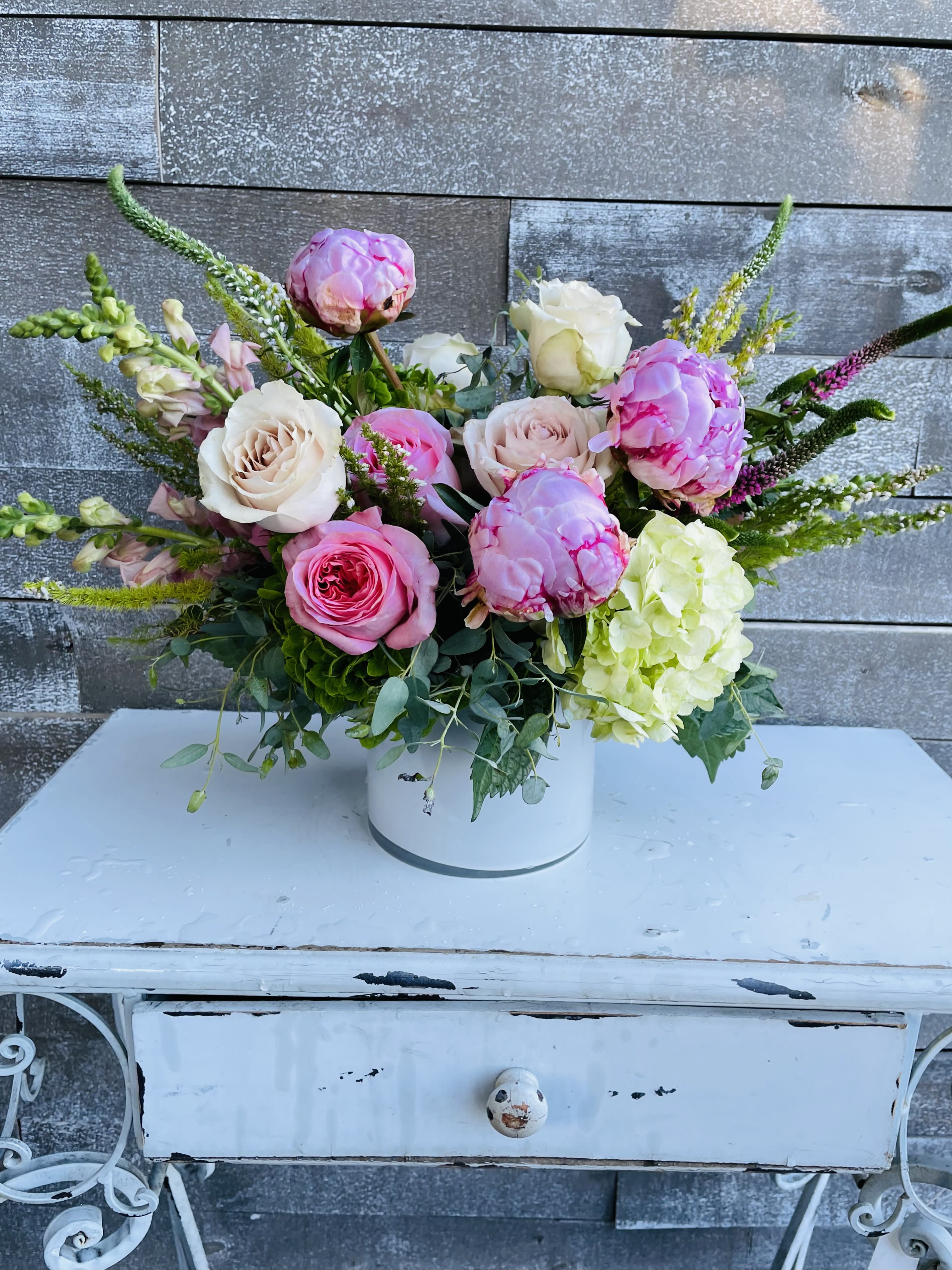 Pink and white roses with hydrangea in a white vase