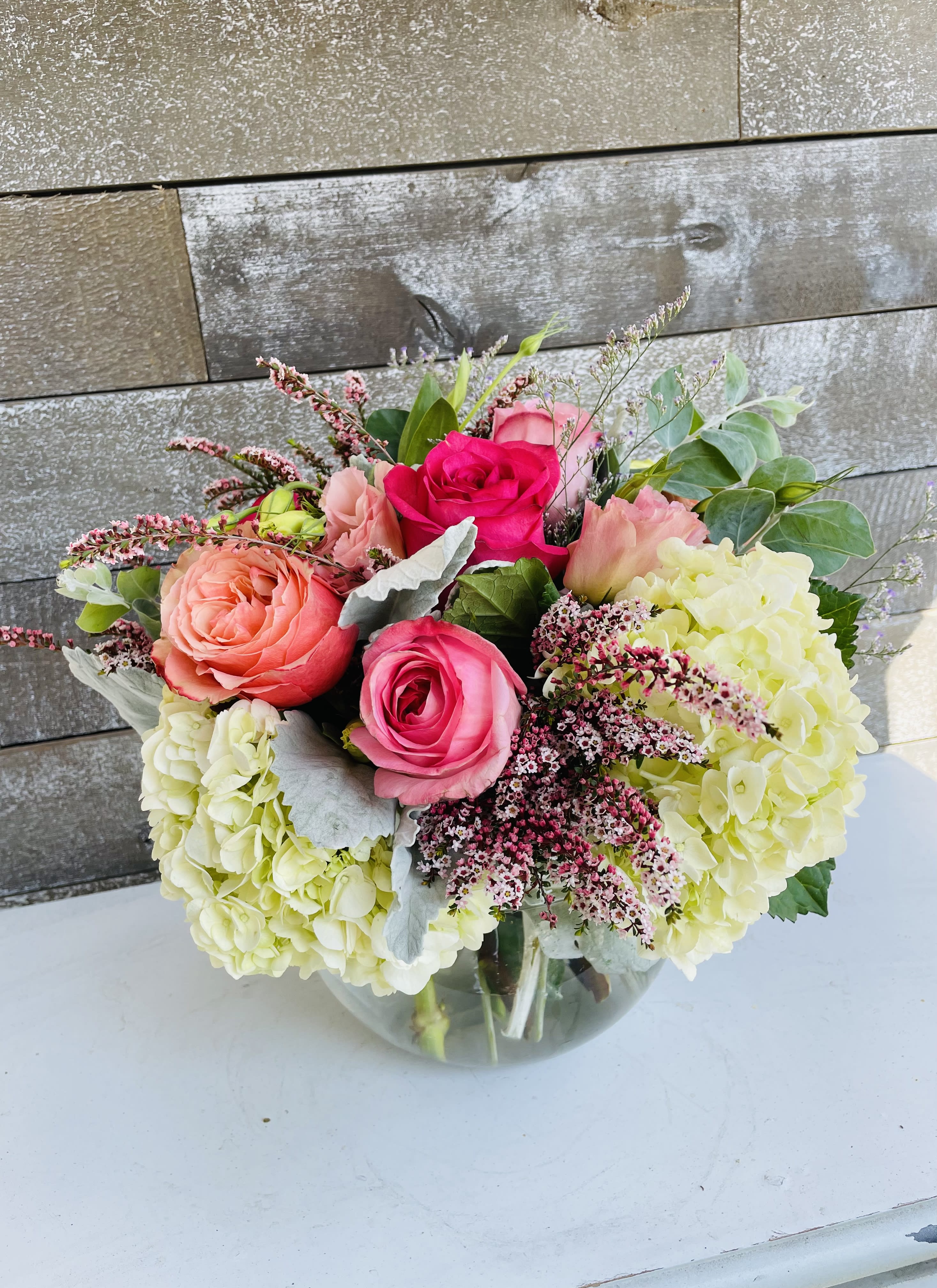 Bouquet of pink roses and pale hydrangeas in a glass vase