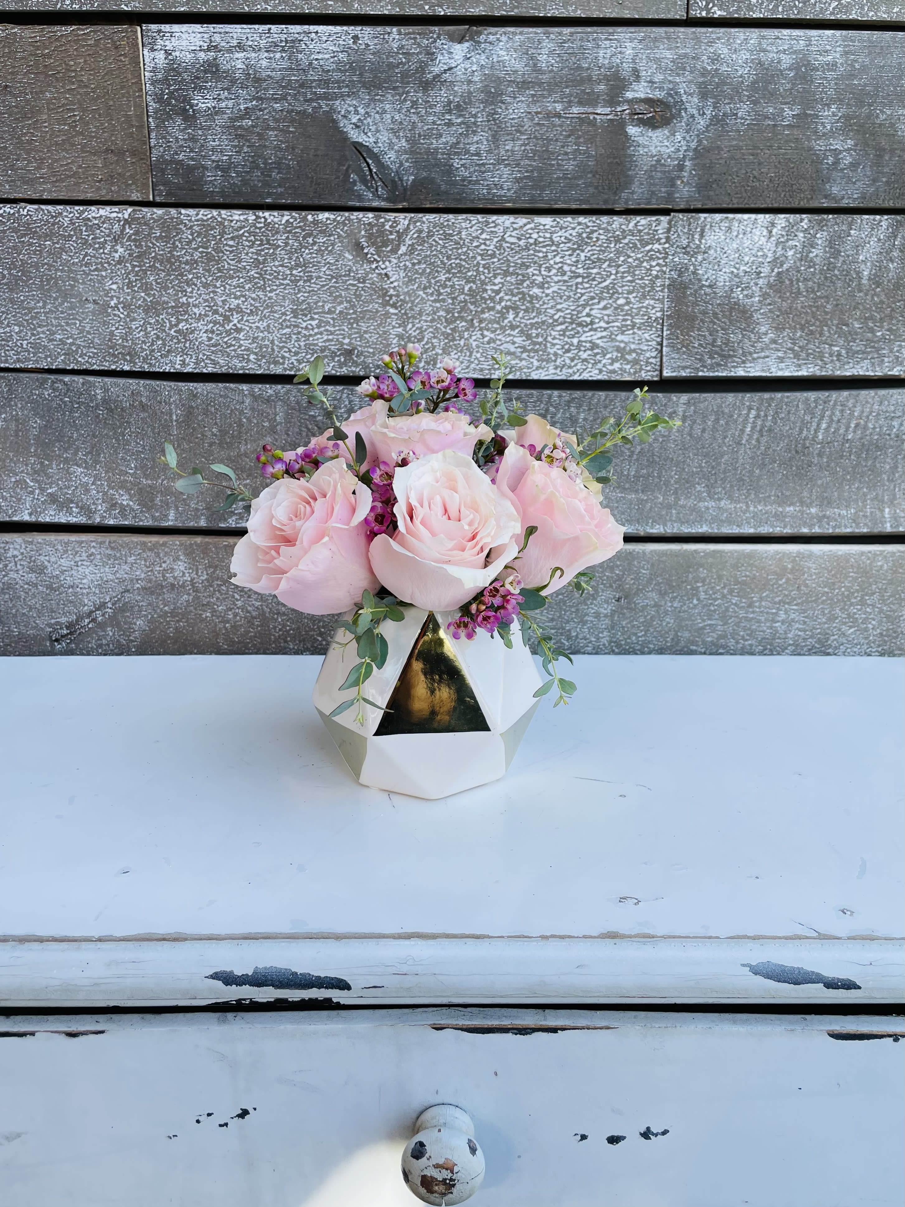 Pink roses arranged in a white geometric vase