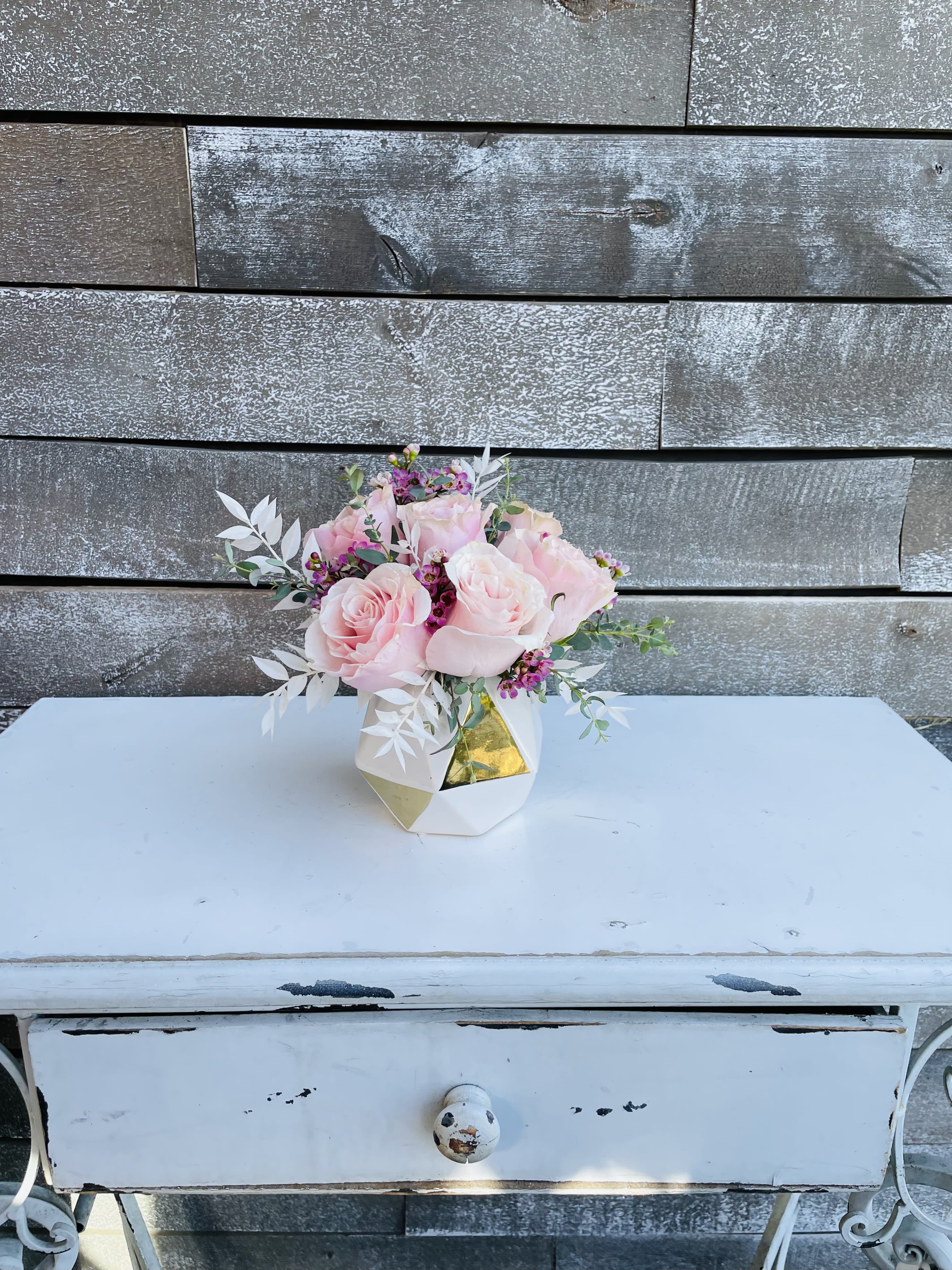 Pink roses arranged in a small geometric vase