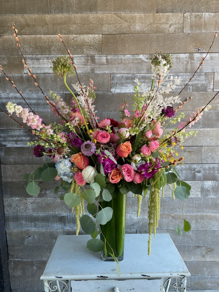 Tall mixed bouquet in a glass vase with pink, peach, and white flowers