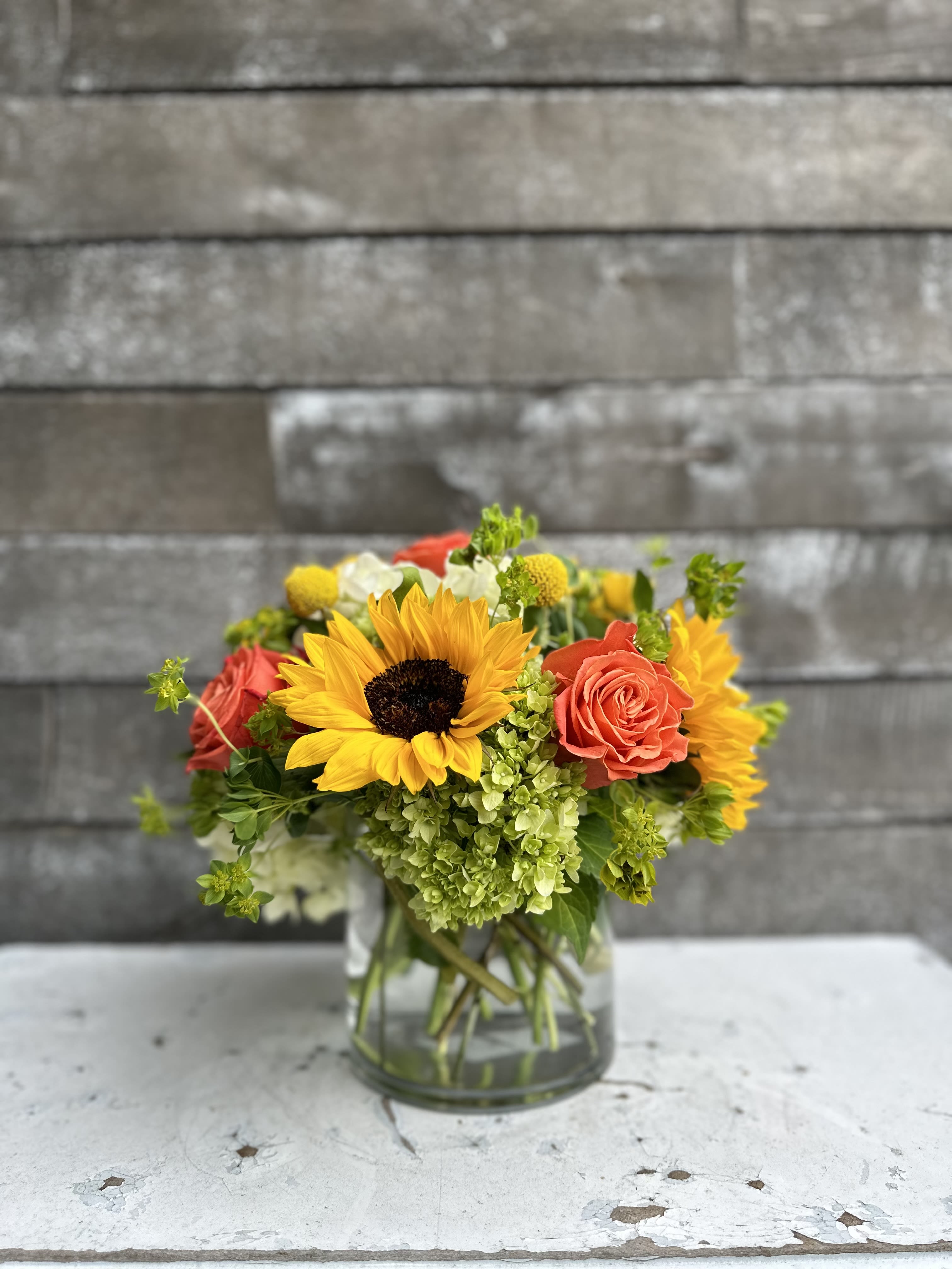 Sunflower and rose bouquet in a clear glass vase