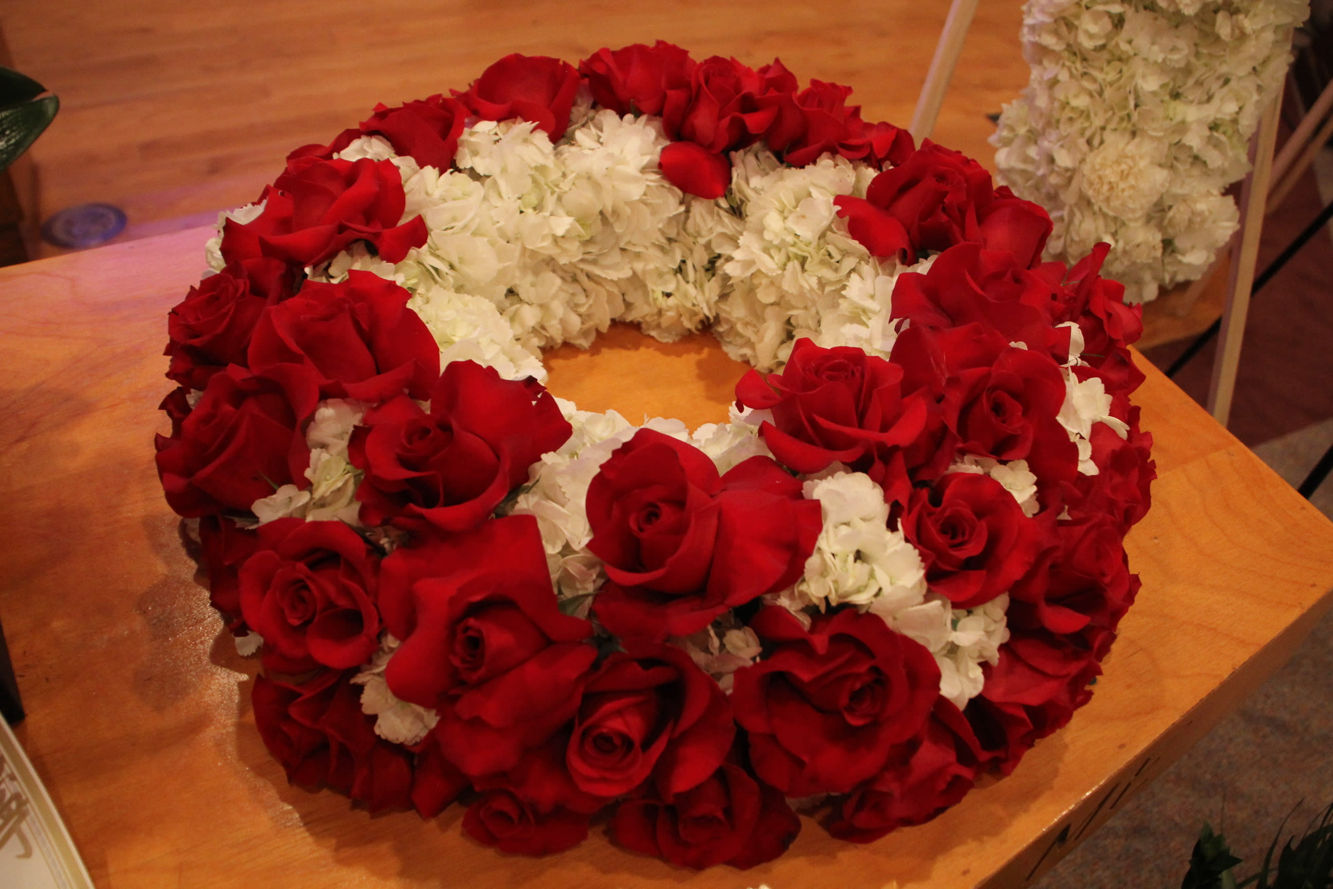 Red roses and white flowers arranged in a circular wreath