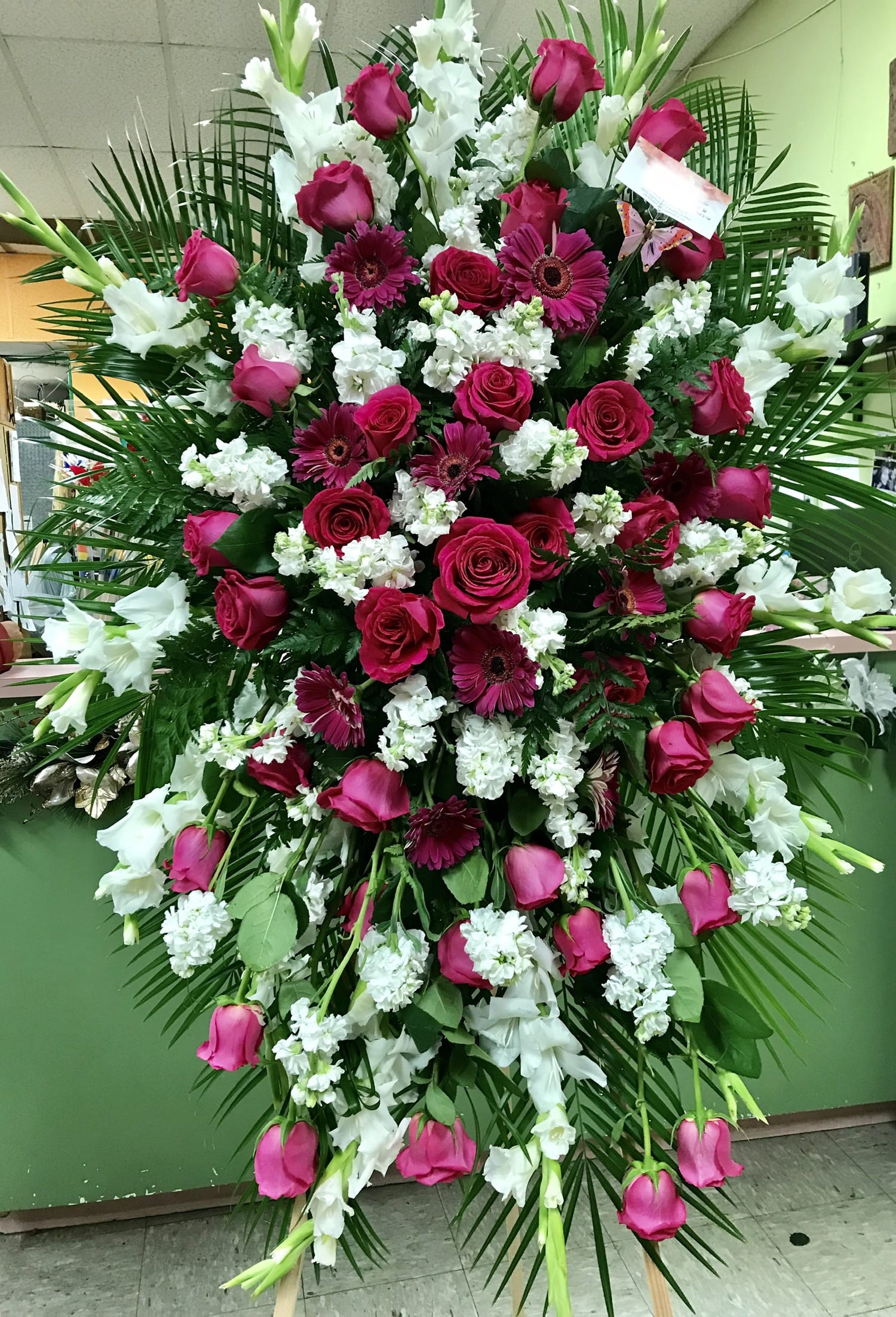 Large standing spray of pink roses, gerbera daisies, and white flowers