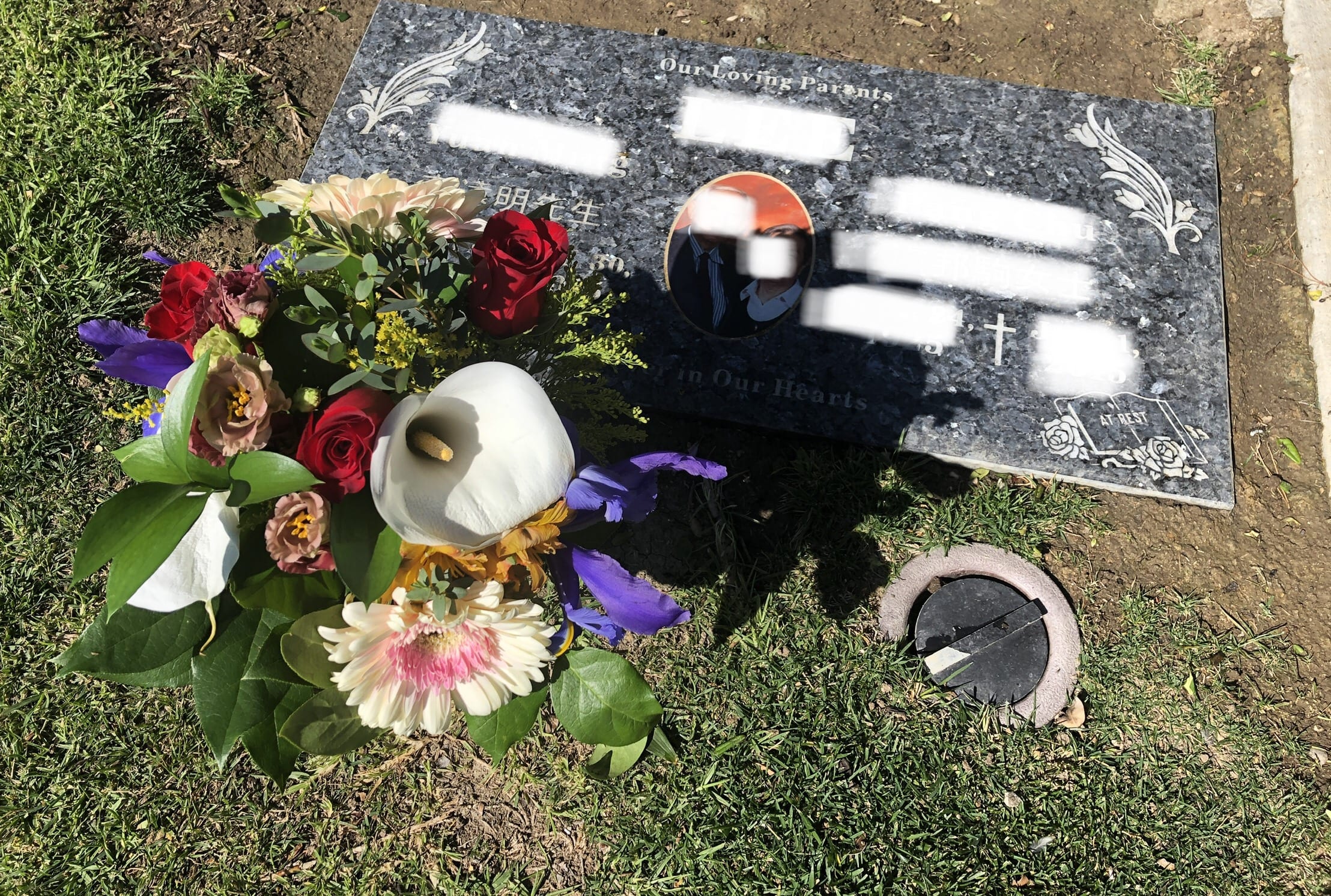Bouquet of mixed flowers placed beside a gravestone