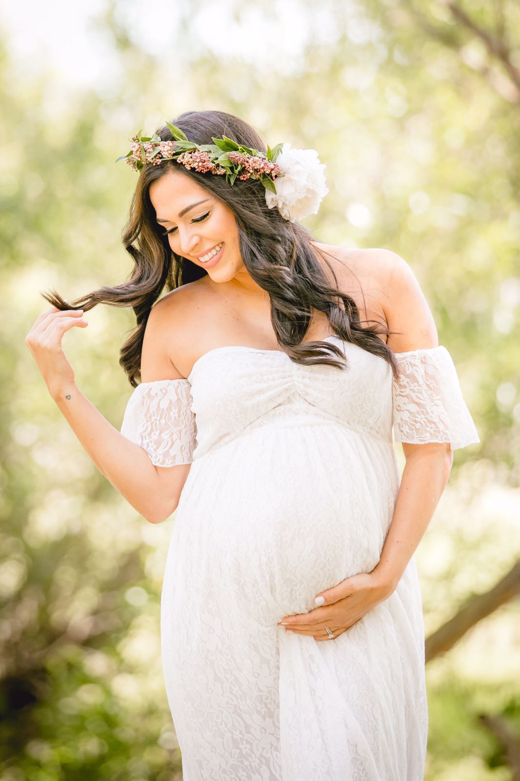 Pregnant woman in a white dress wearing a floral crown