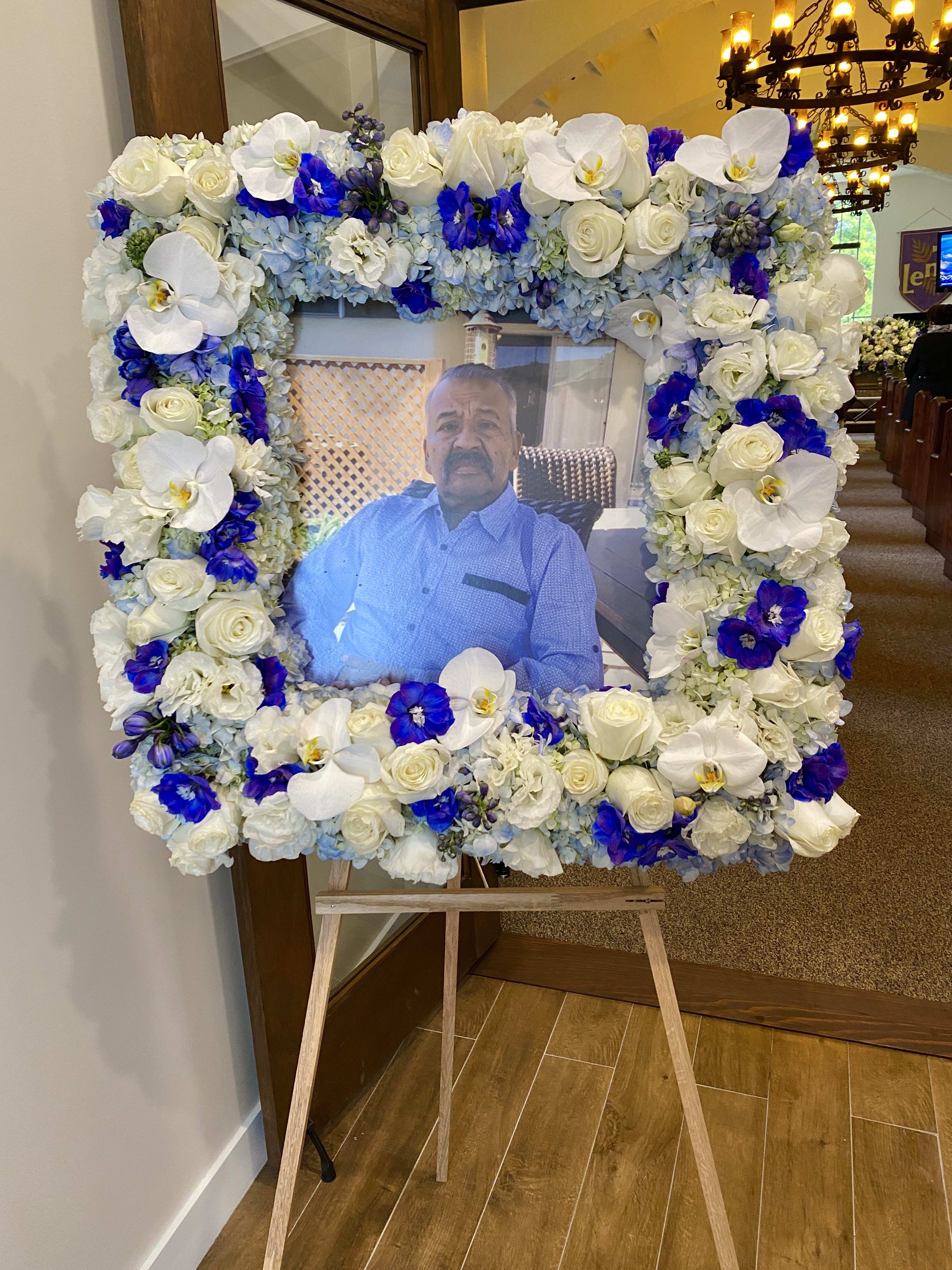 Large floral frame around a portrait on an easel