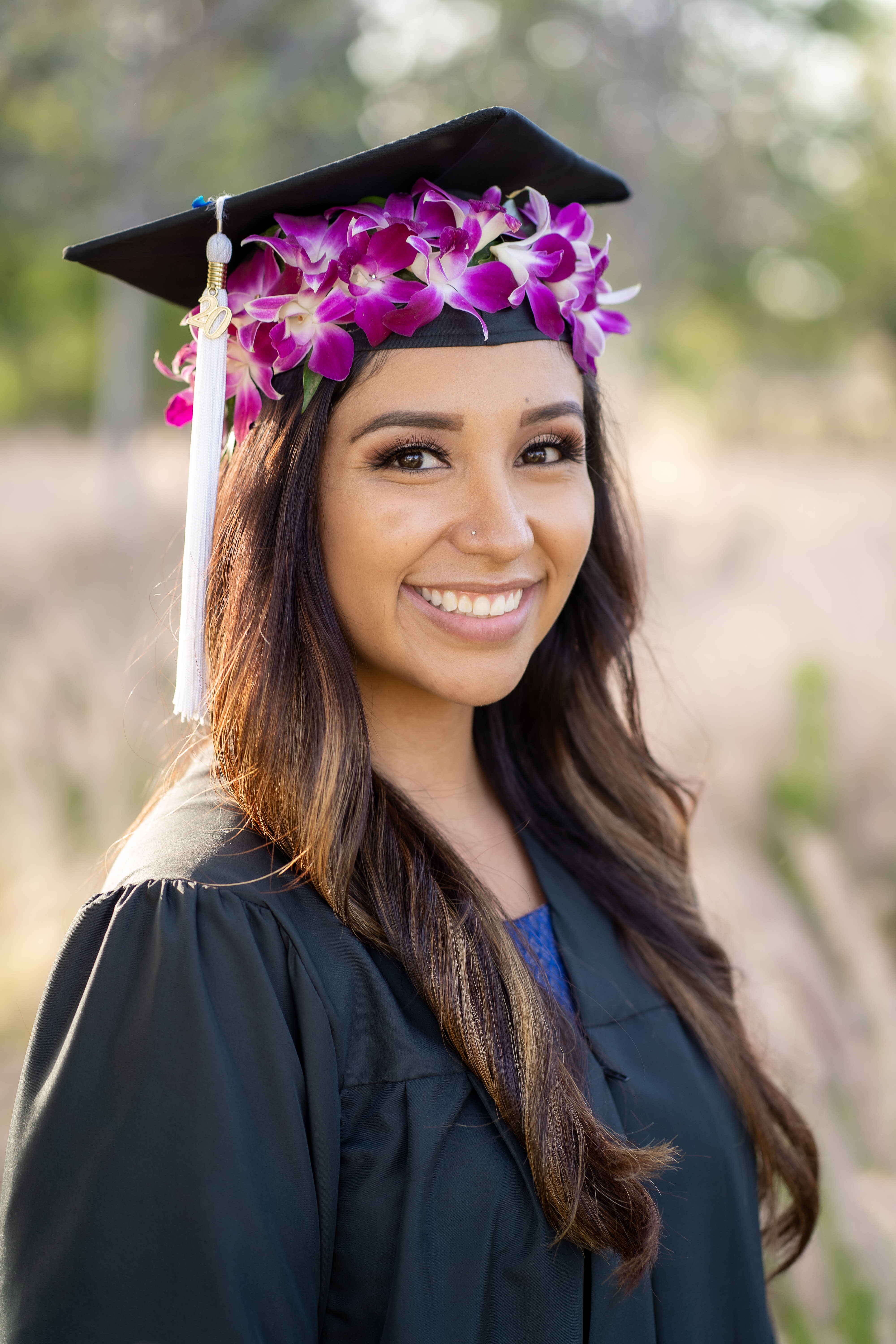 Graduate wearing a cap with purple orchid flowers and a tassel