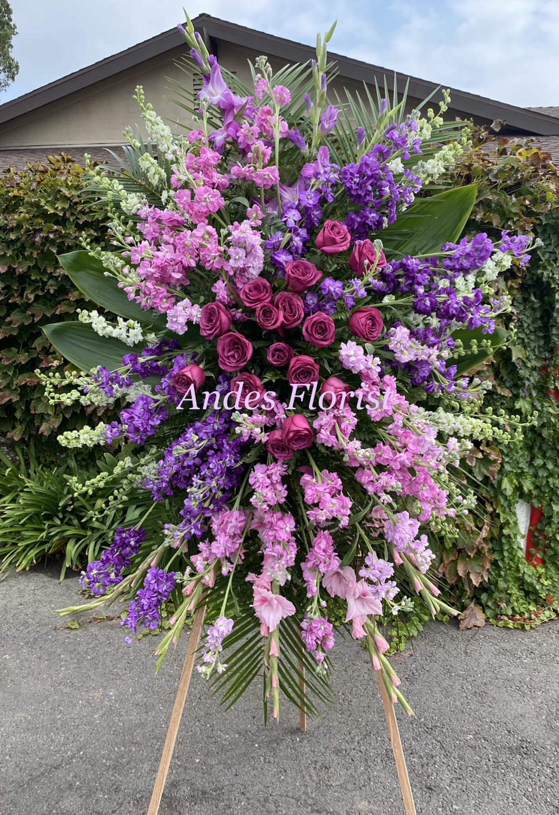 Large standing floral spray with pink and purple roses and blossoms