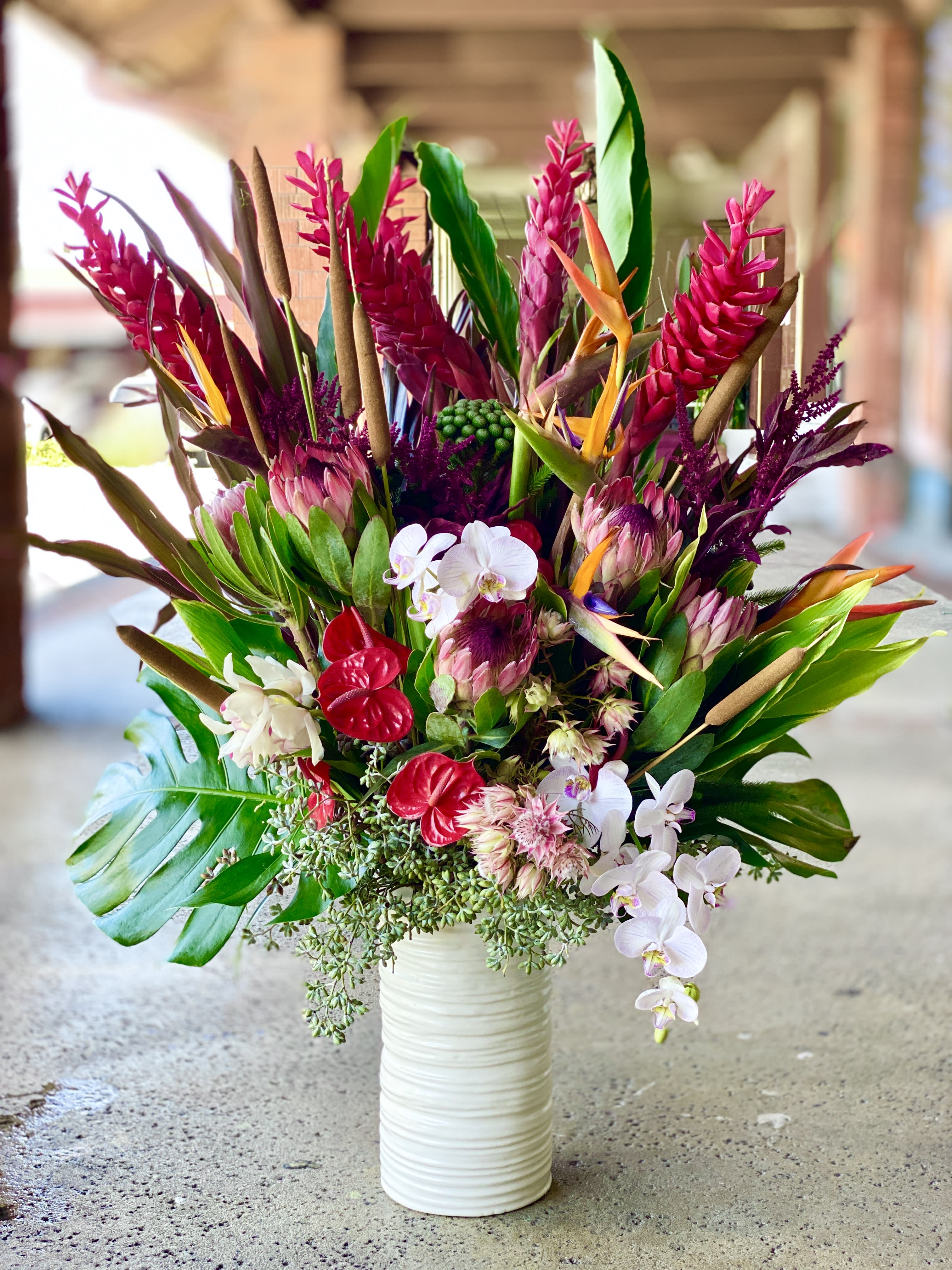 Tropical bouquet in a white vase with pink and white orchids