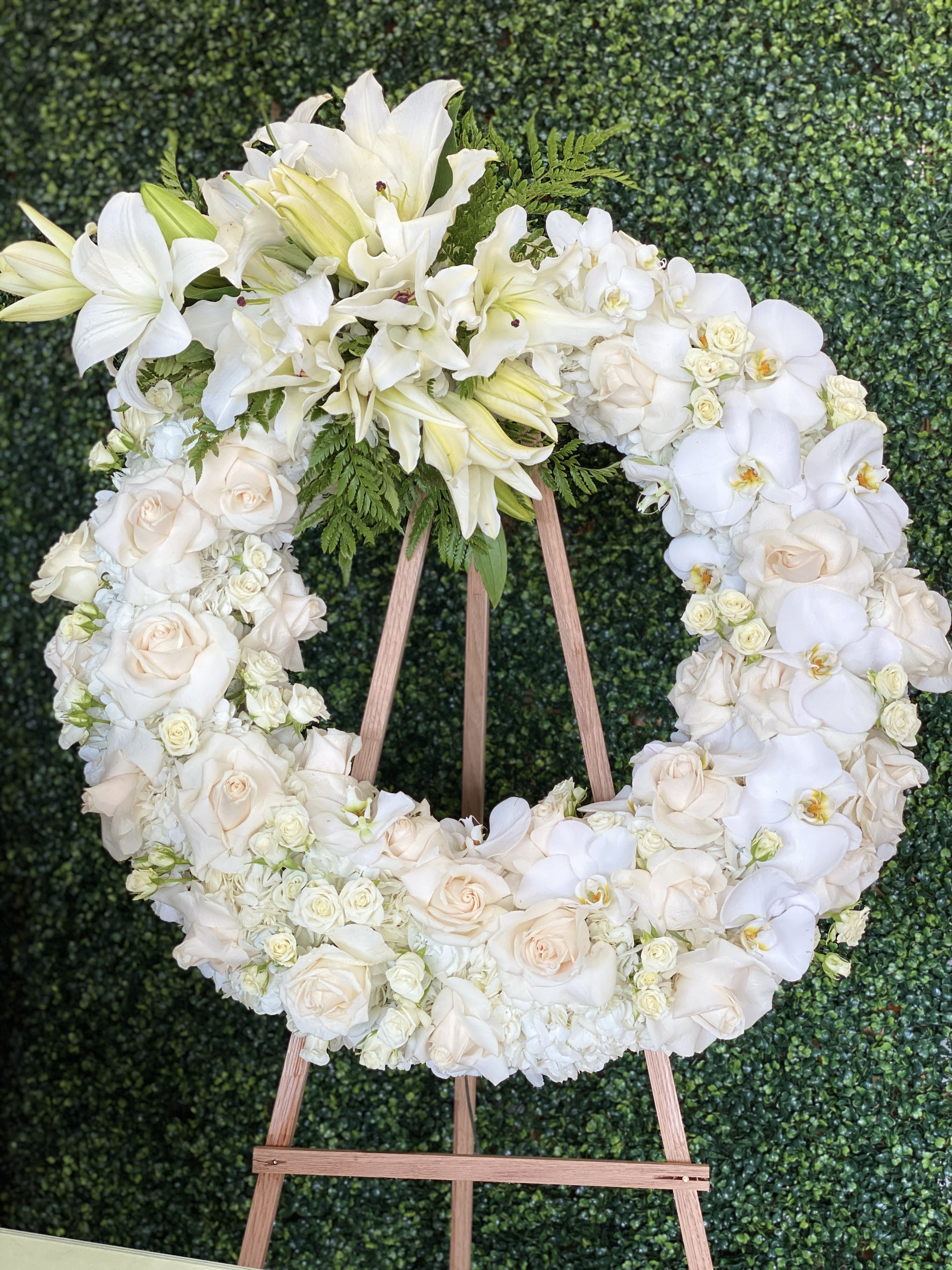 White floral wreath on a wooden easel