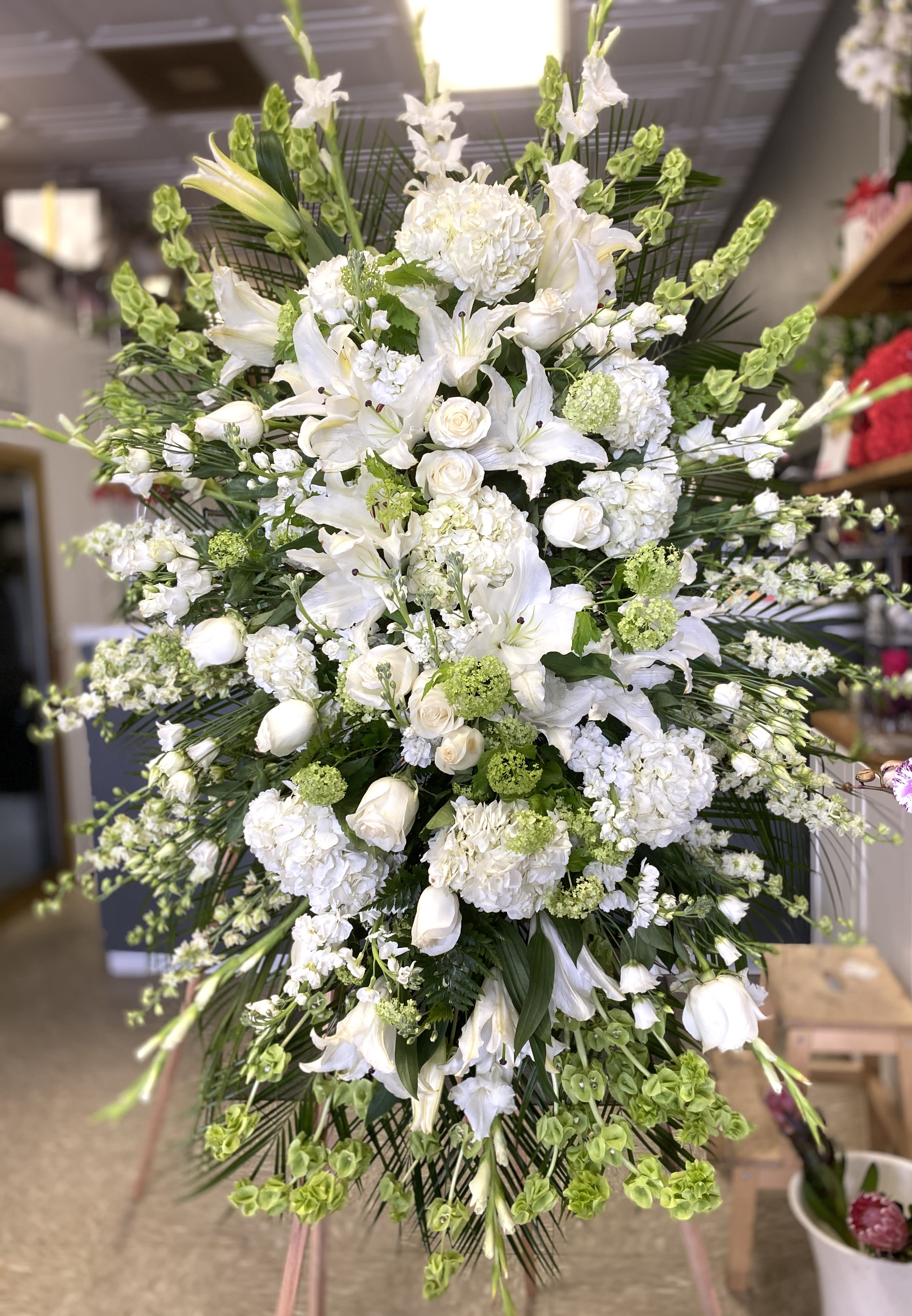 Large white floral standing spray with lilies and roses