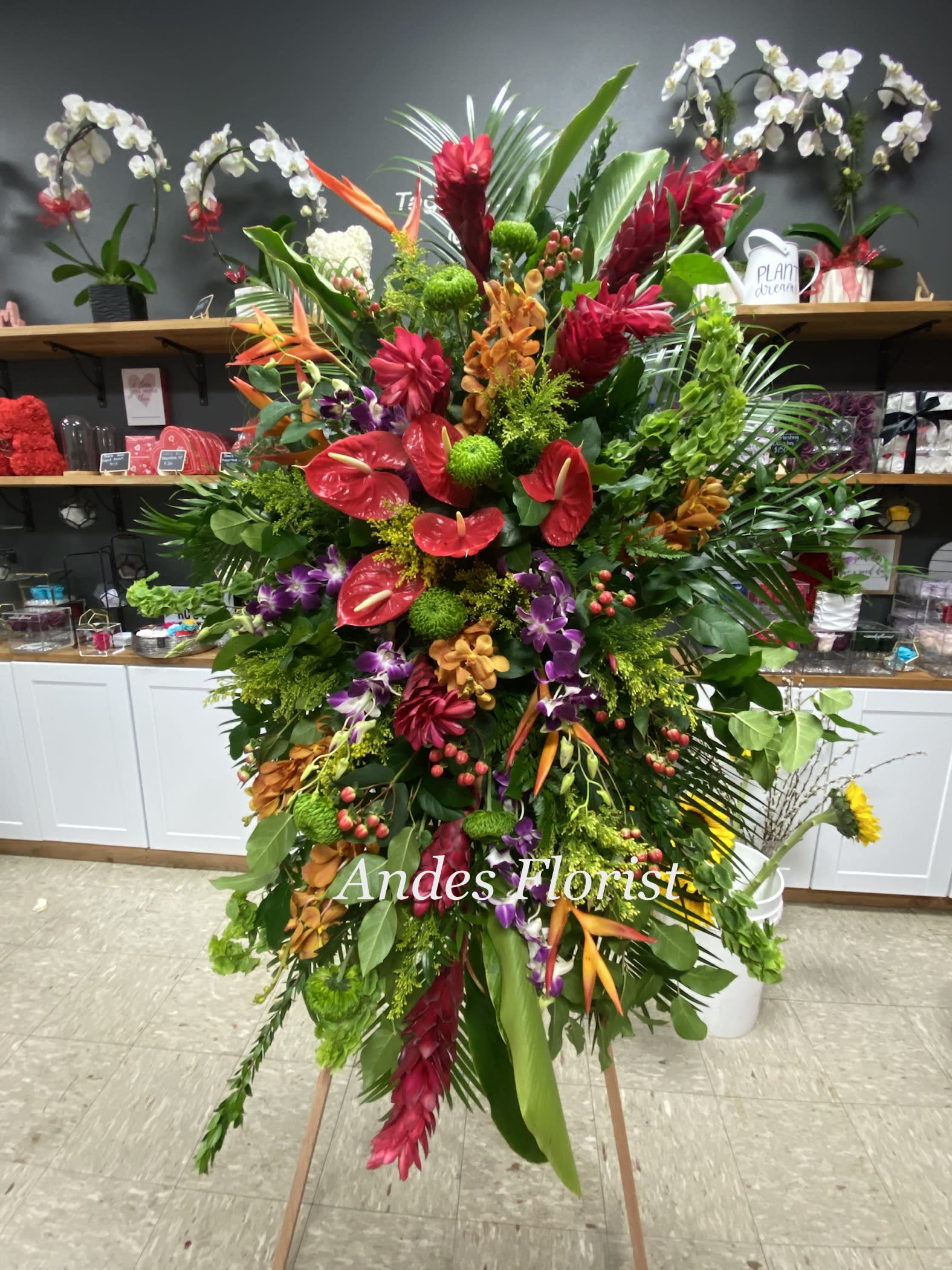 Large tropical floral standing spray with red, orange, purple, and green blooms