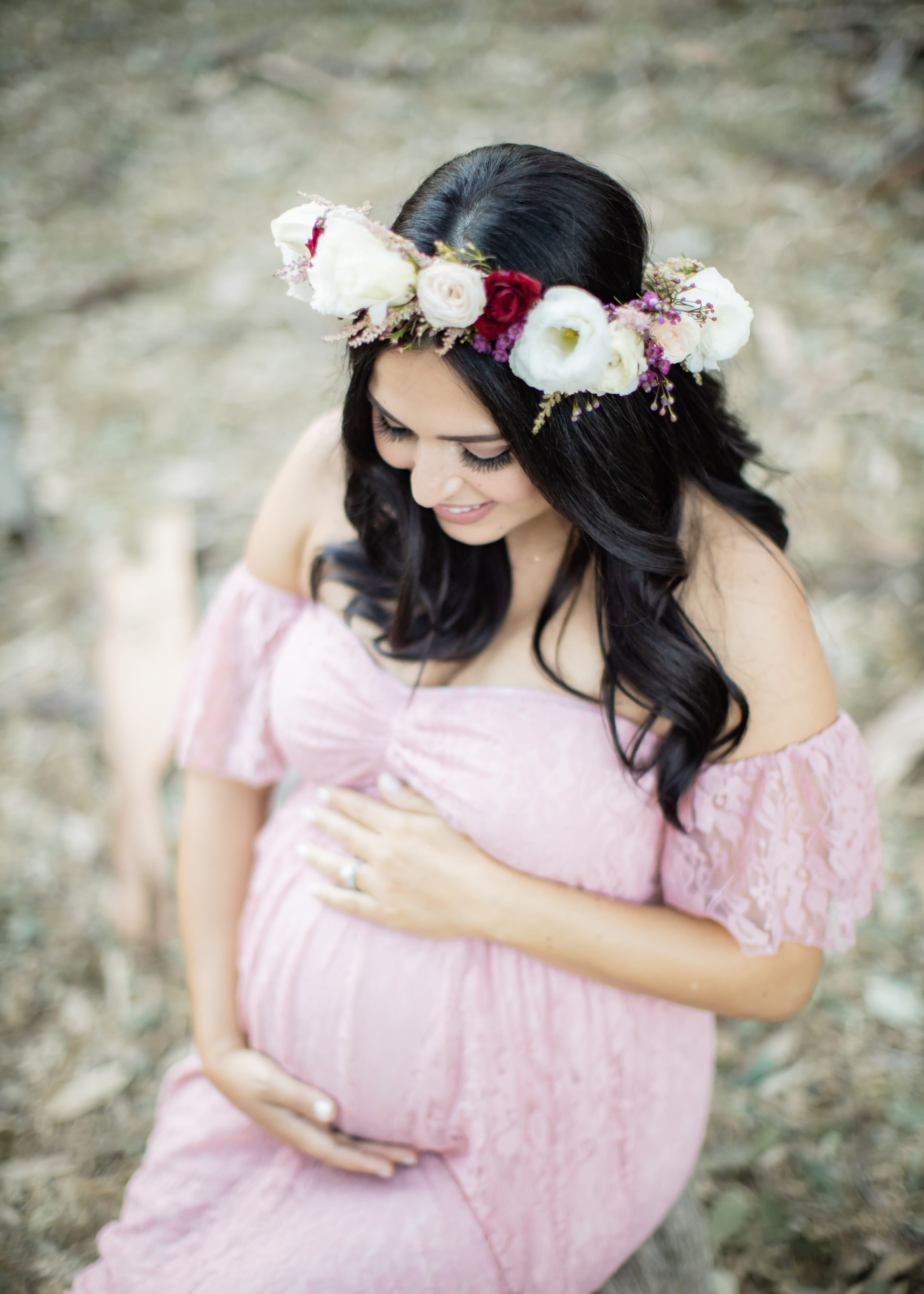 Pregnant woman in a pink dress wearing a floral crown