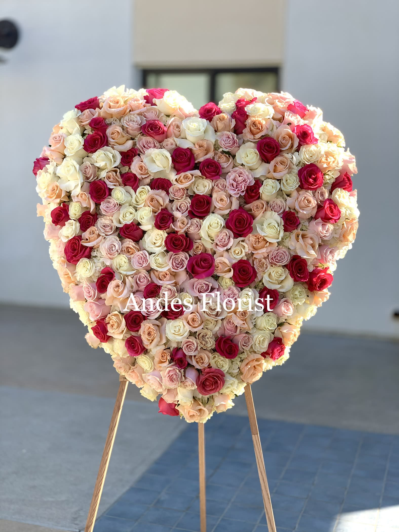 Heart-shaped rose arrangement on a stand