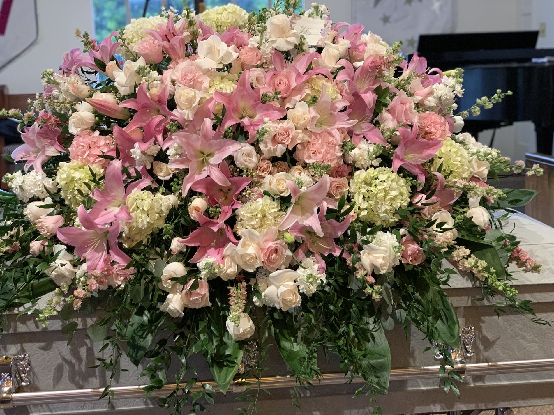 Large pink and white floral casket spray with lilies and roses