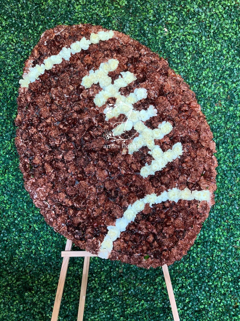 Football-shaped floral display on a wooden easel