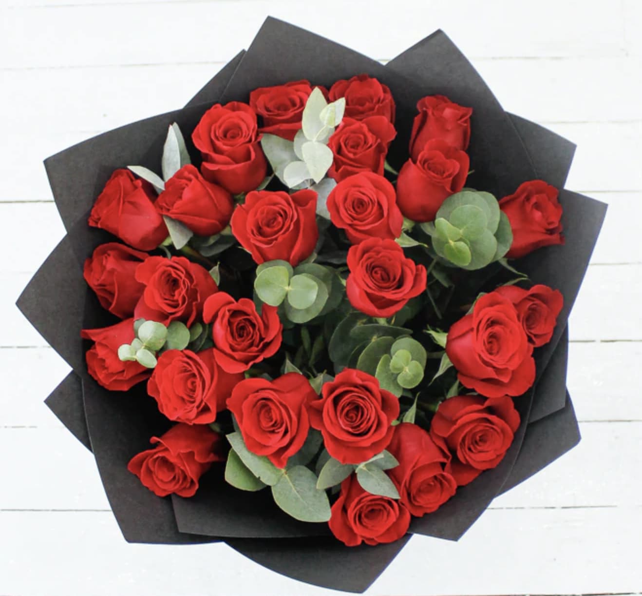 Bouquet of red roses wrapped in black paper