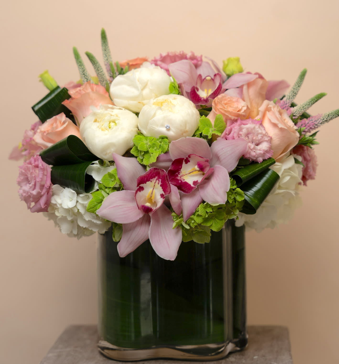 Pink and white floral arrangement in a tall glass vase