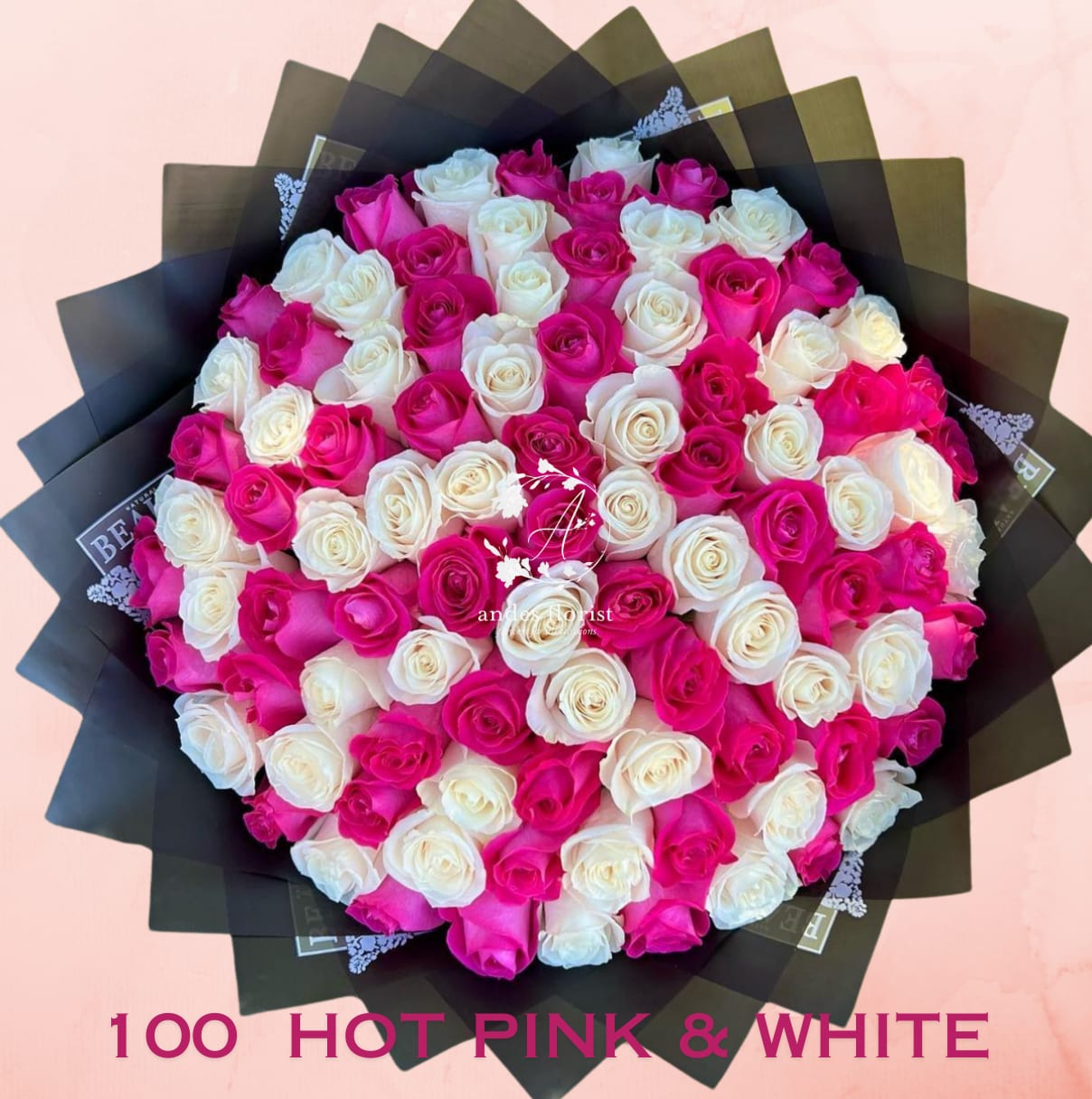 Bouquet of hot pink and white roses wrapped in black paper