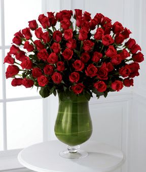 Large bouquet of red roses in a green glass vase