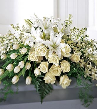 White lilies and roses arranged in a low floral display