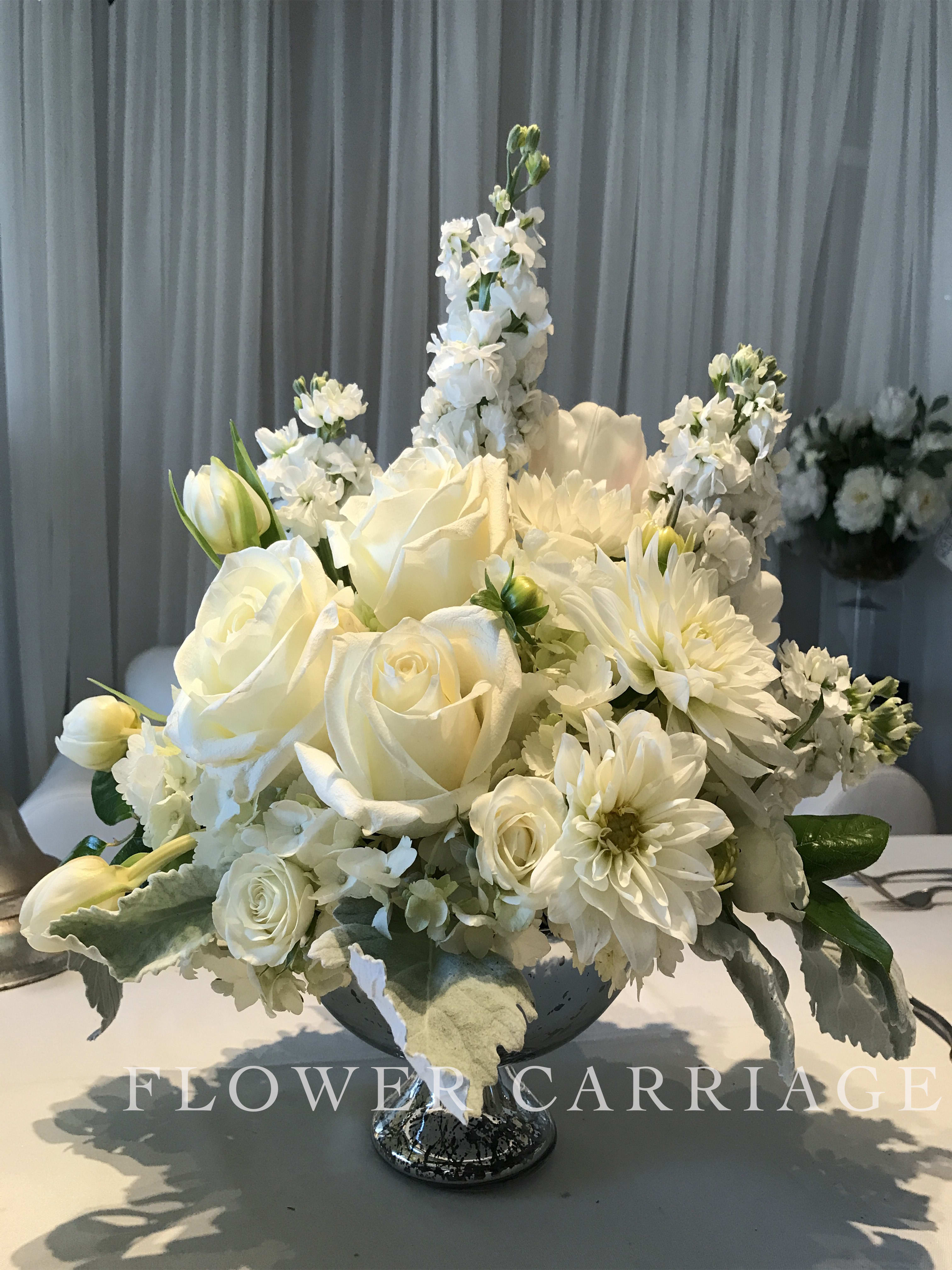 White floral centerpiece in a silver pedestal bowl