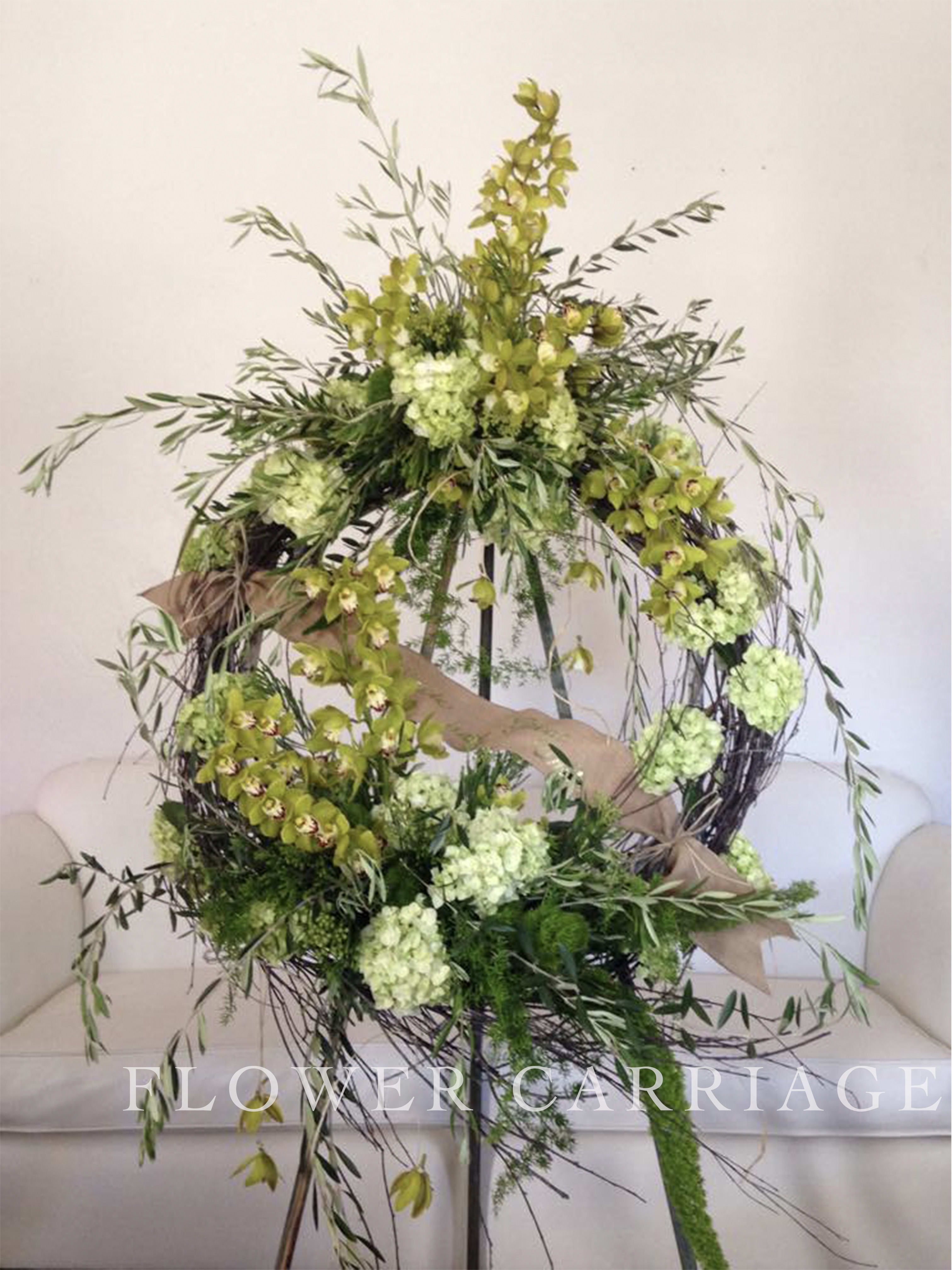 Large circular floral wreath with green orchids and pale green blooms