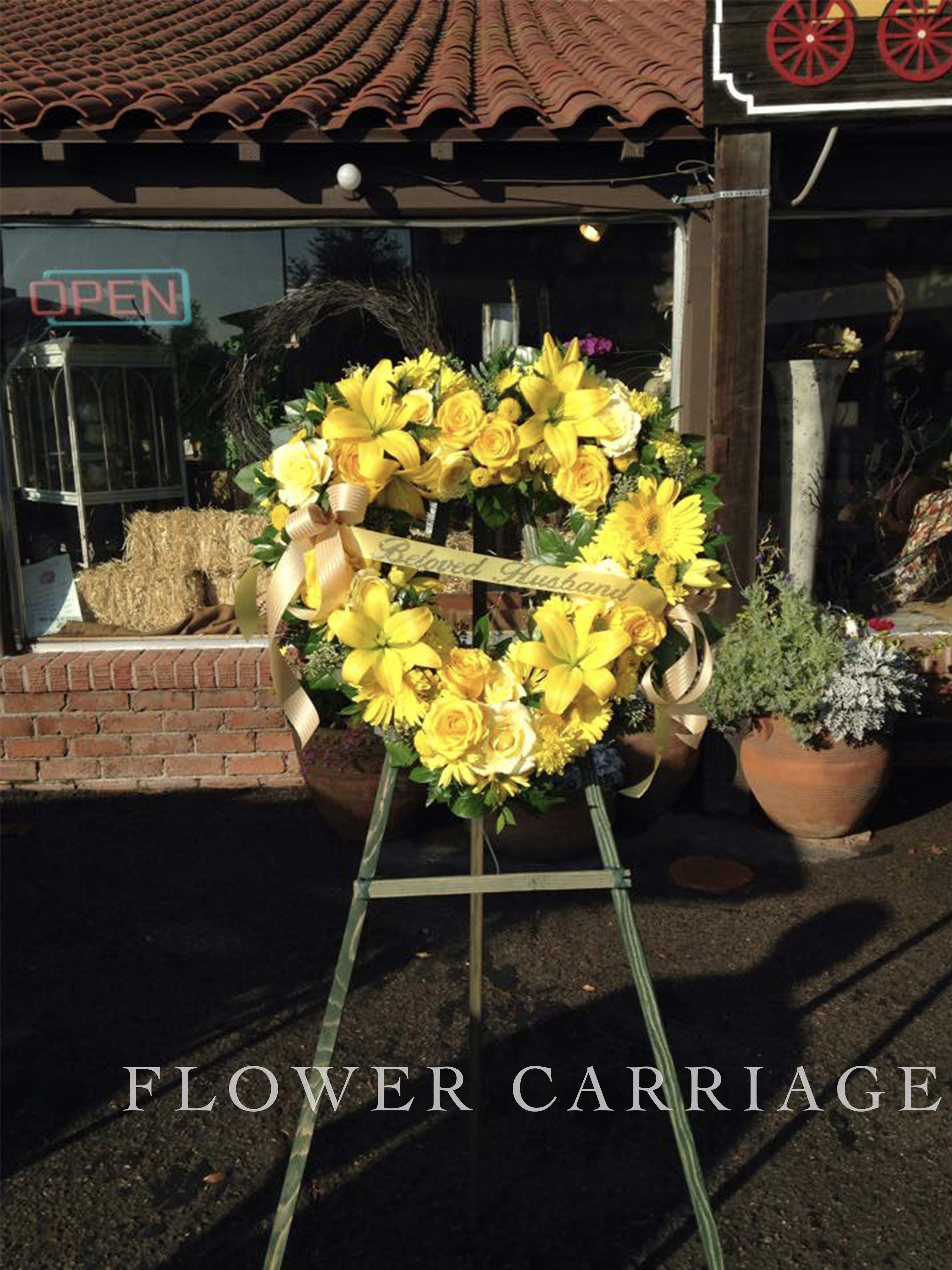 Yellow floral wreath on an easel with ribbon