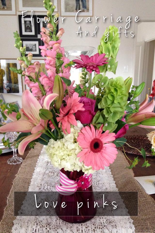 Pink and green floral arrangement in a vase with lilies and gerbera daisies