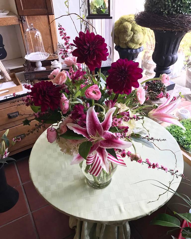 Pink lilies and dark magenta dahlias in a glass vase