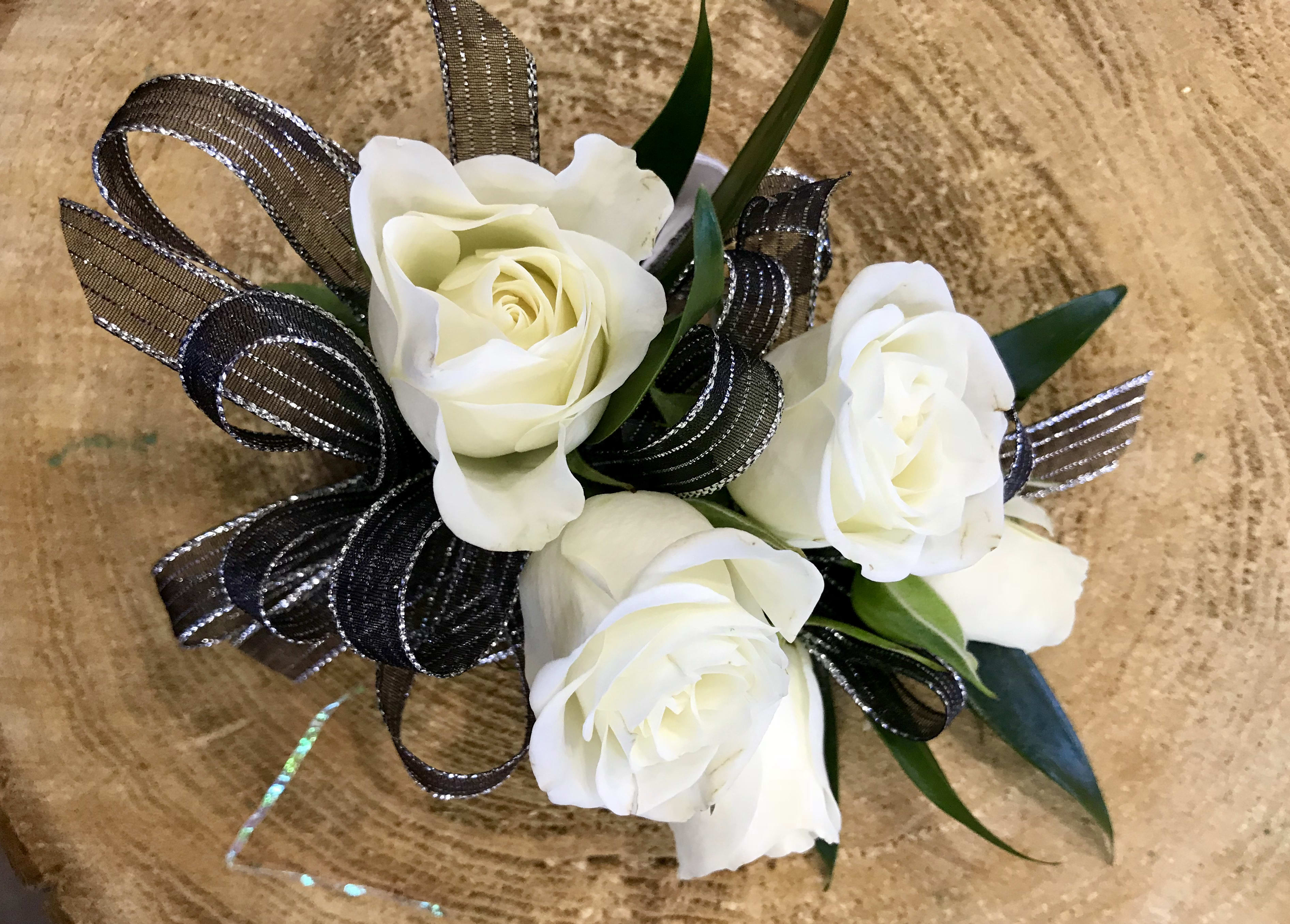 Small bouquet of white roses with black ribbon loops
