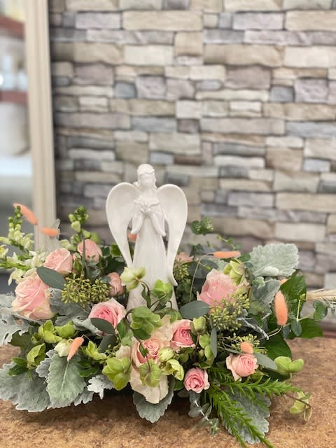 Pink rose arrangement with a white angel figurine centerpiece