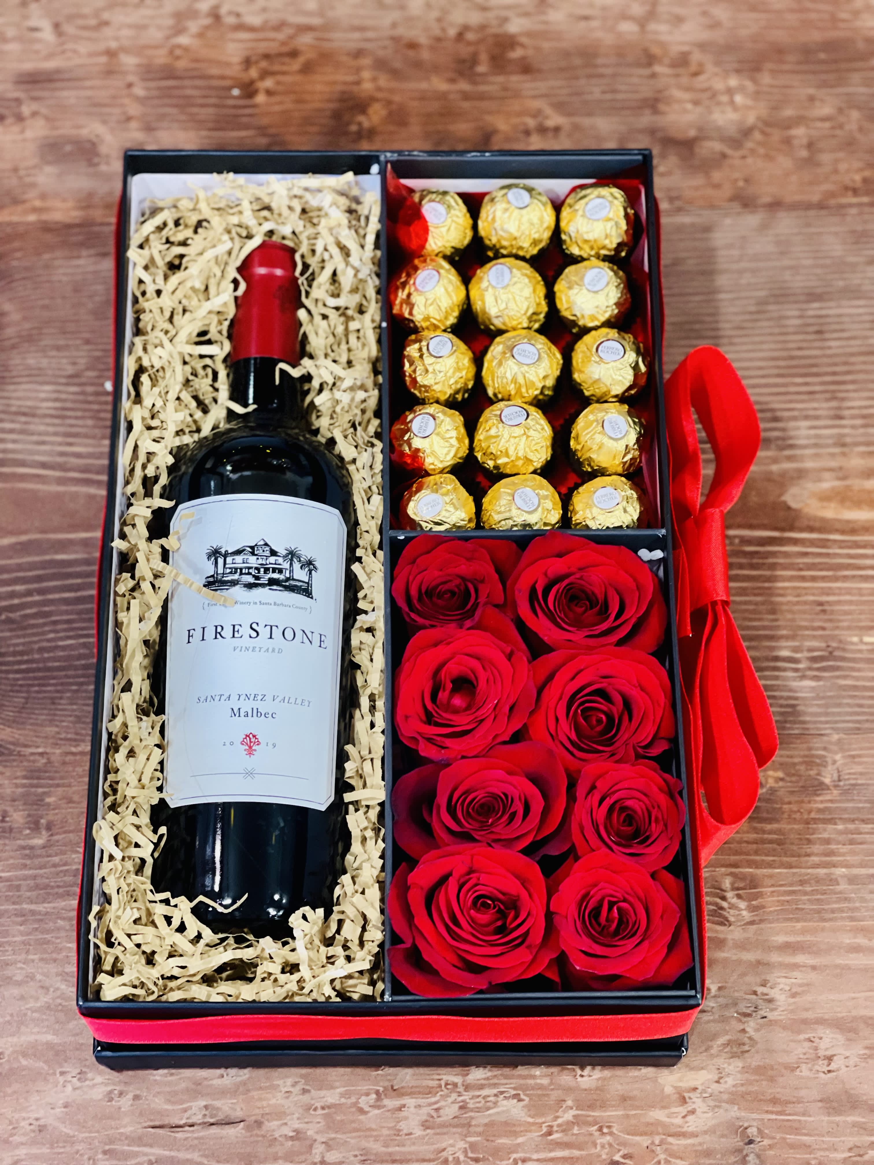 Gift box with a wine bottle, chocolates, and red roses