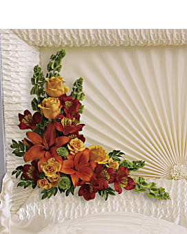 Orange and red floral spray on a white casket
