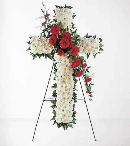 Cross-shaped floral standing spray with white and red flowers on an easel