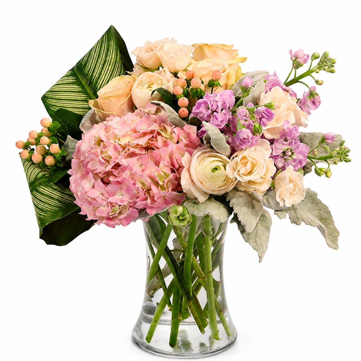 Pink and peach flowers arranged in a clear glass vase