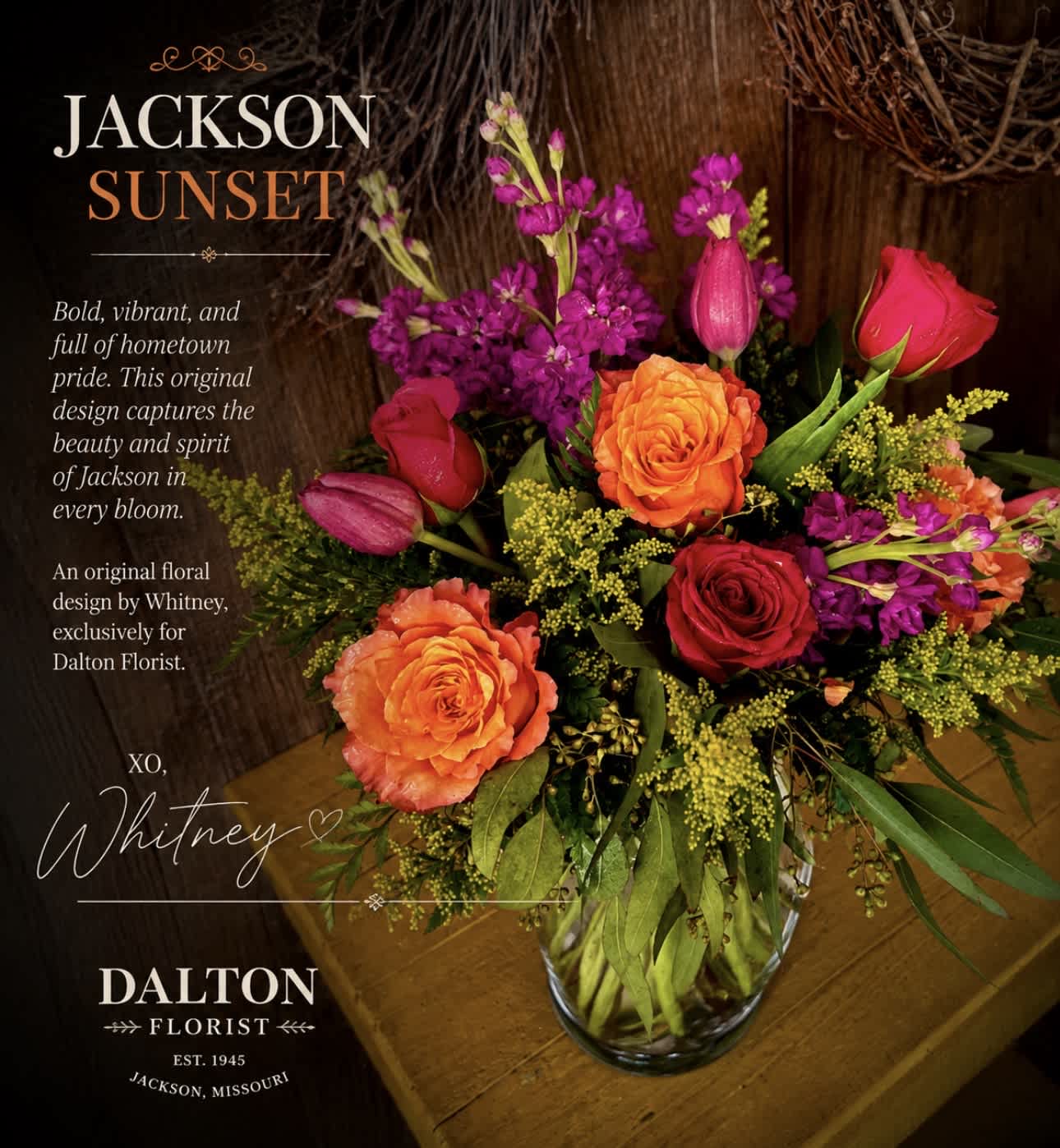 Mixed bouquet of orange and red roses with purple blooms in a glass vase