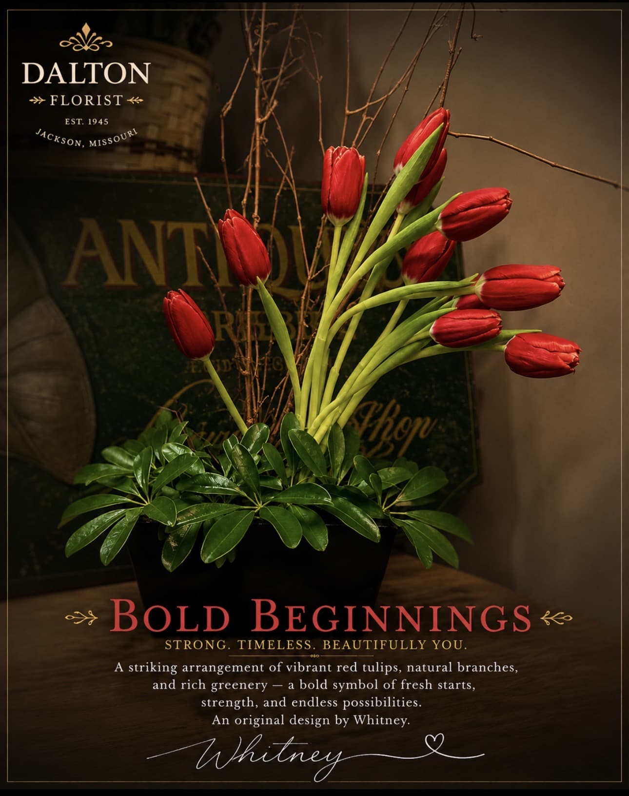 Arrangement of red tulips in a black container with branches