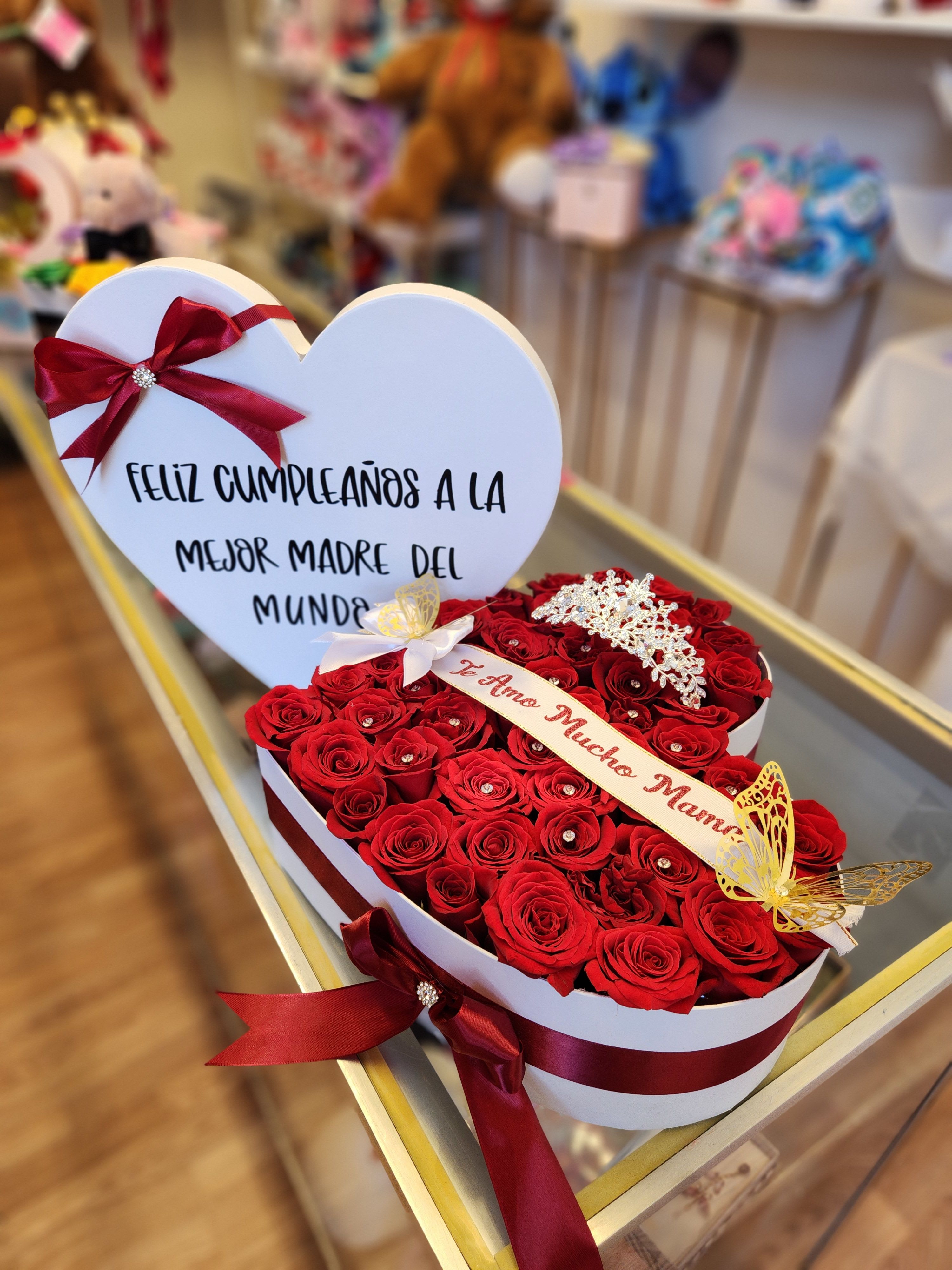 Heart-shaped box of red roses with a birthday message card and ribbon