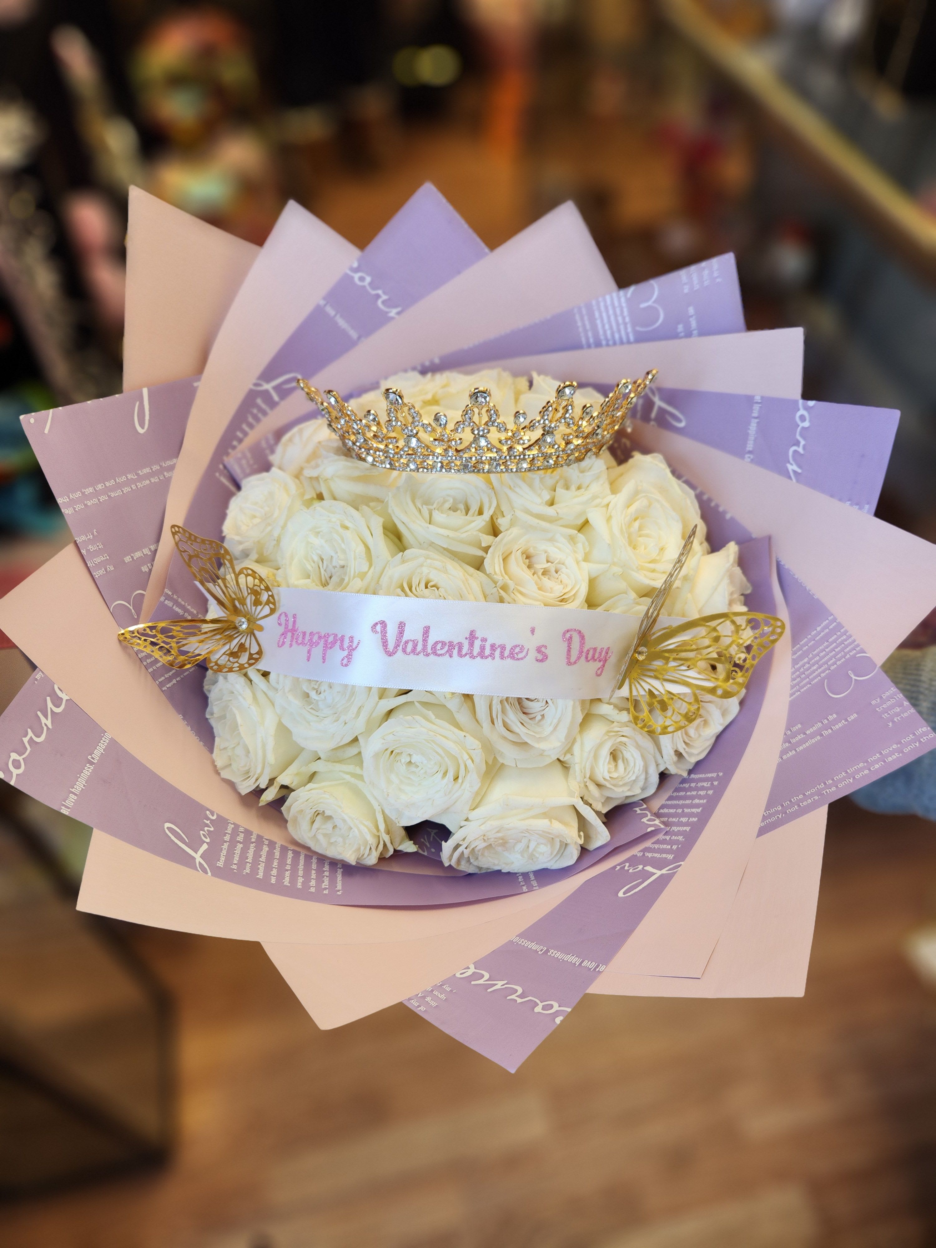 Bouquet of white roses with a jeweled crown and butterfly decorations