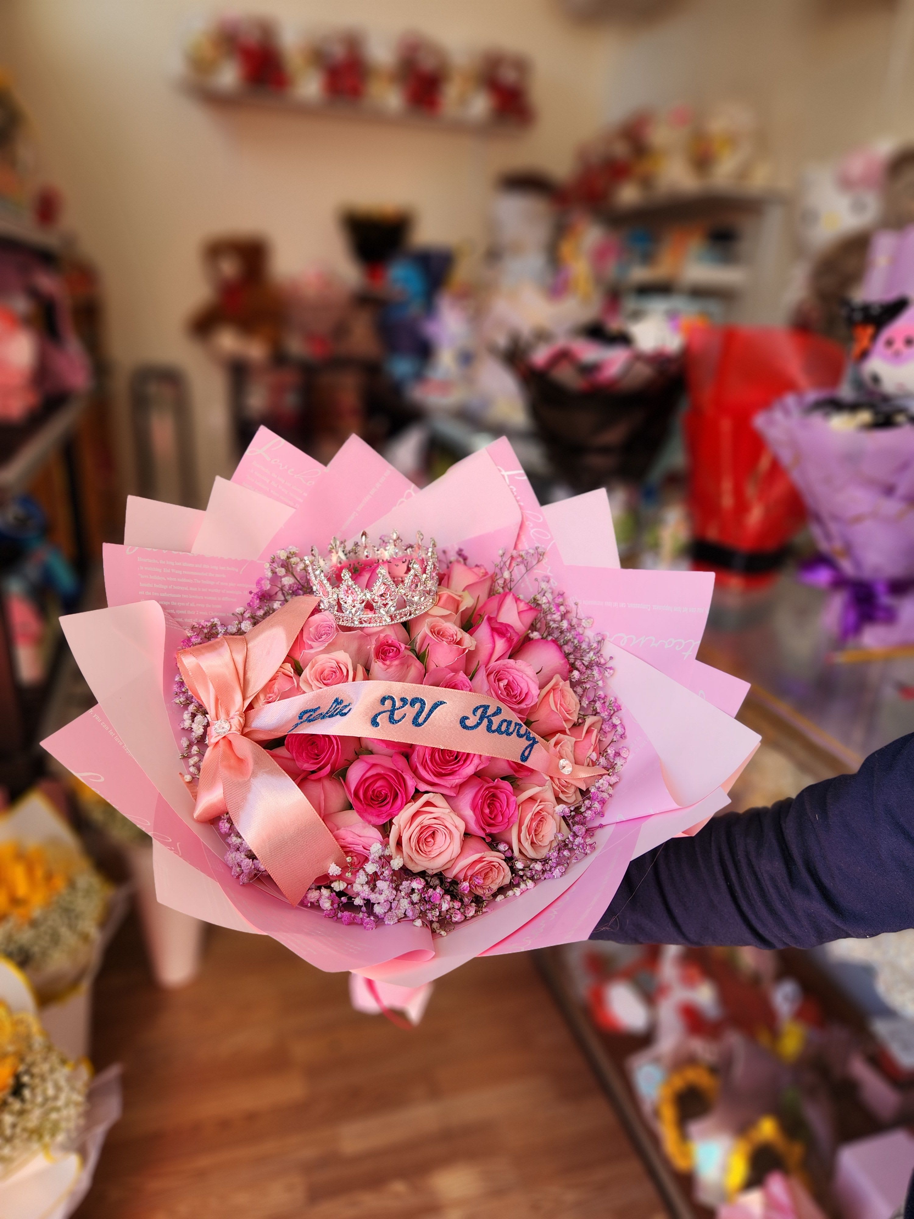 Pink rose bouquet with a ribbon and jeweled crown topper